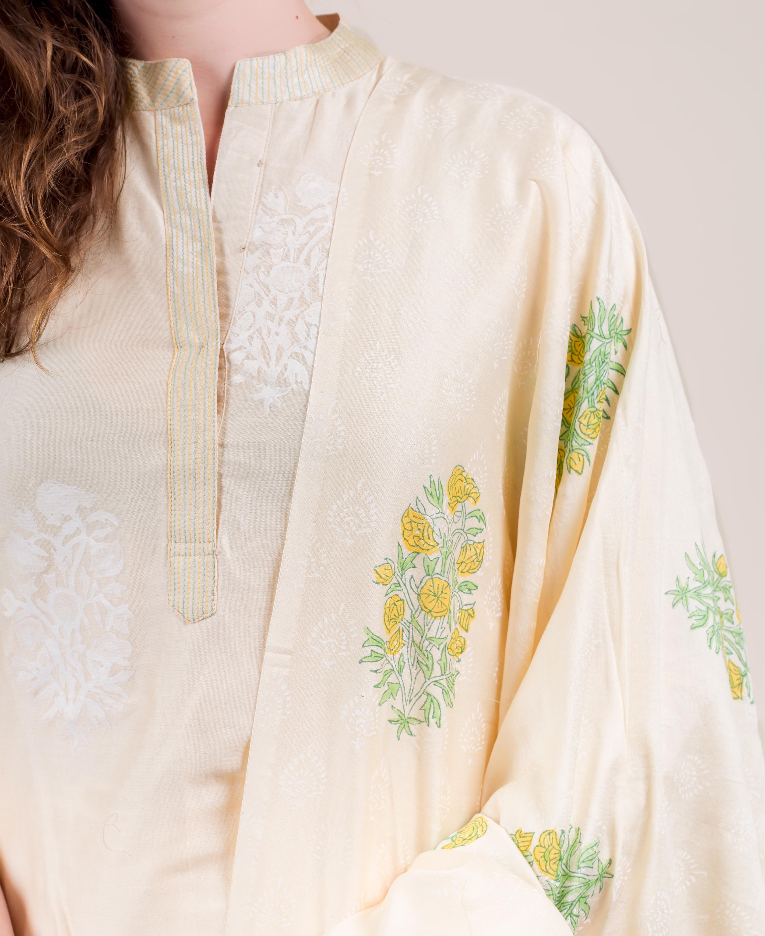 Cream kurta worn by model, featuring subtle patterns and yellow floral block prints.