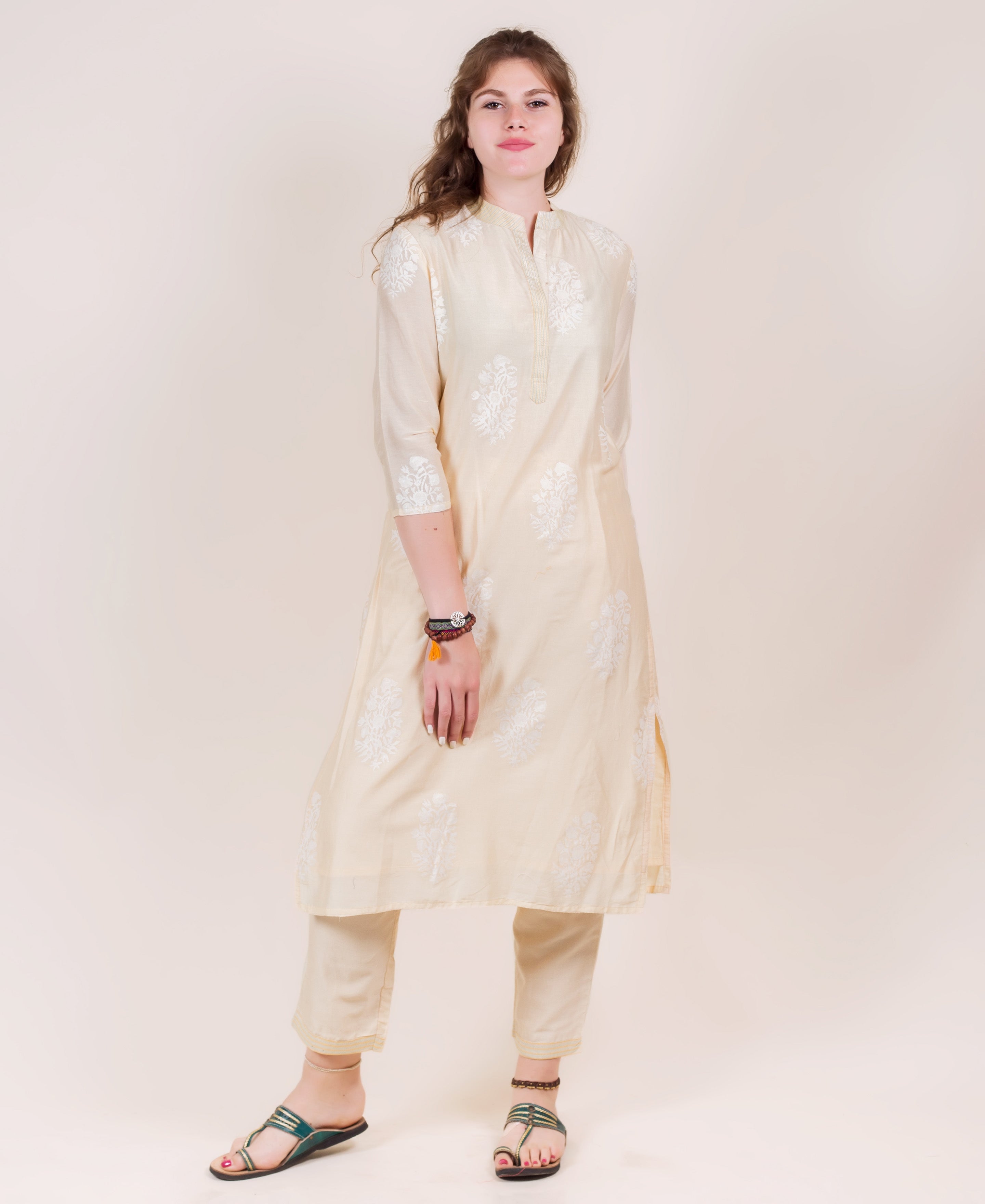 A model wears a cream straight-cut kurta and pants with white hand-block prints.
