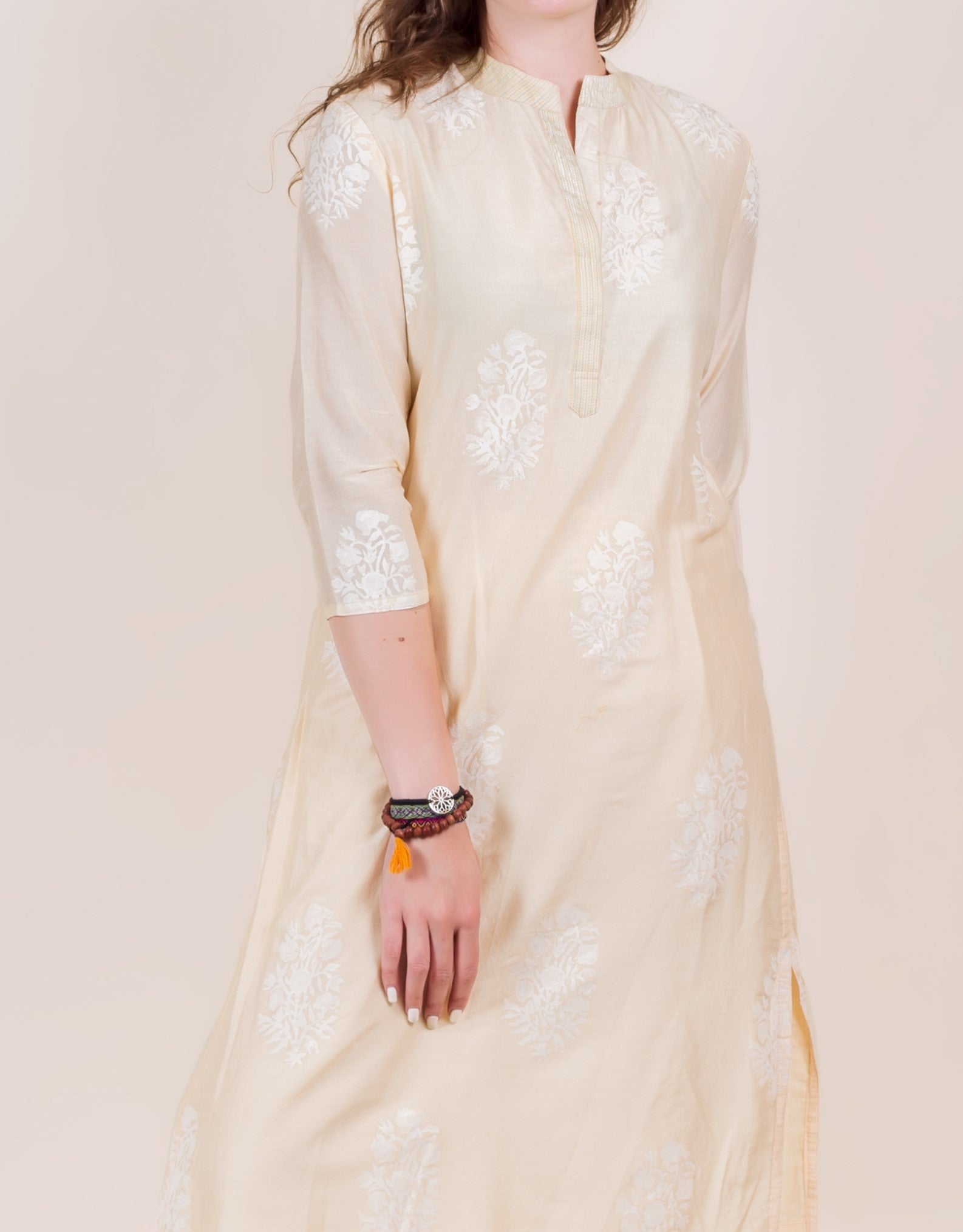 Model wears a light cream straight-cut kurta with white floral hand-block prints.