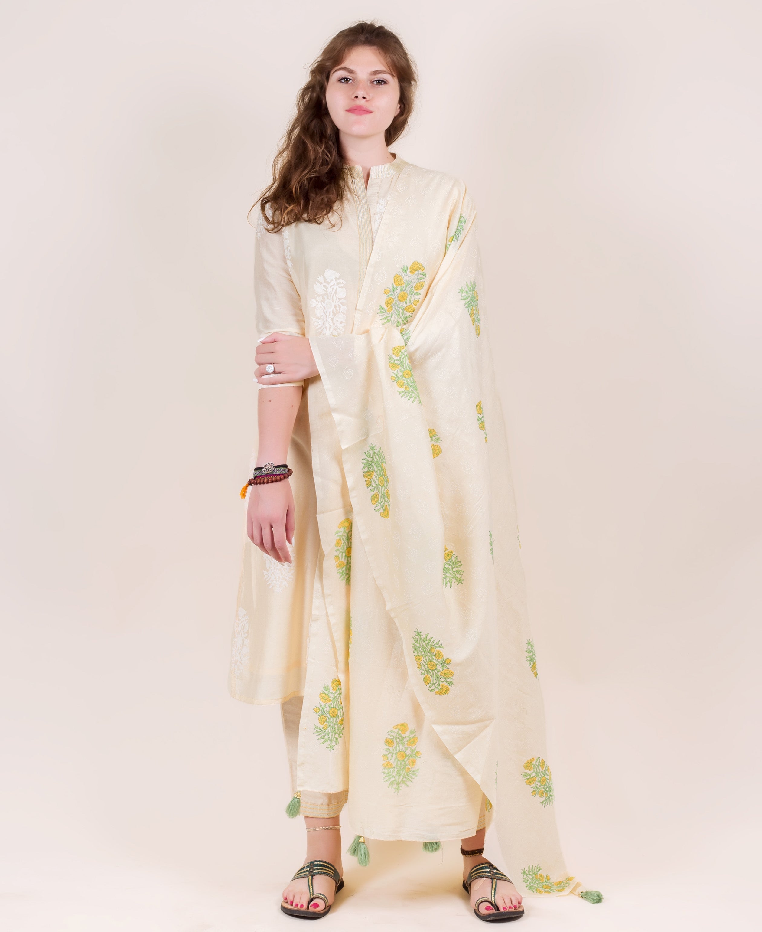 Full-body of woman in cream Chanderi straight-cut kurta set with white, yellow floral prints.