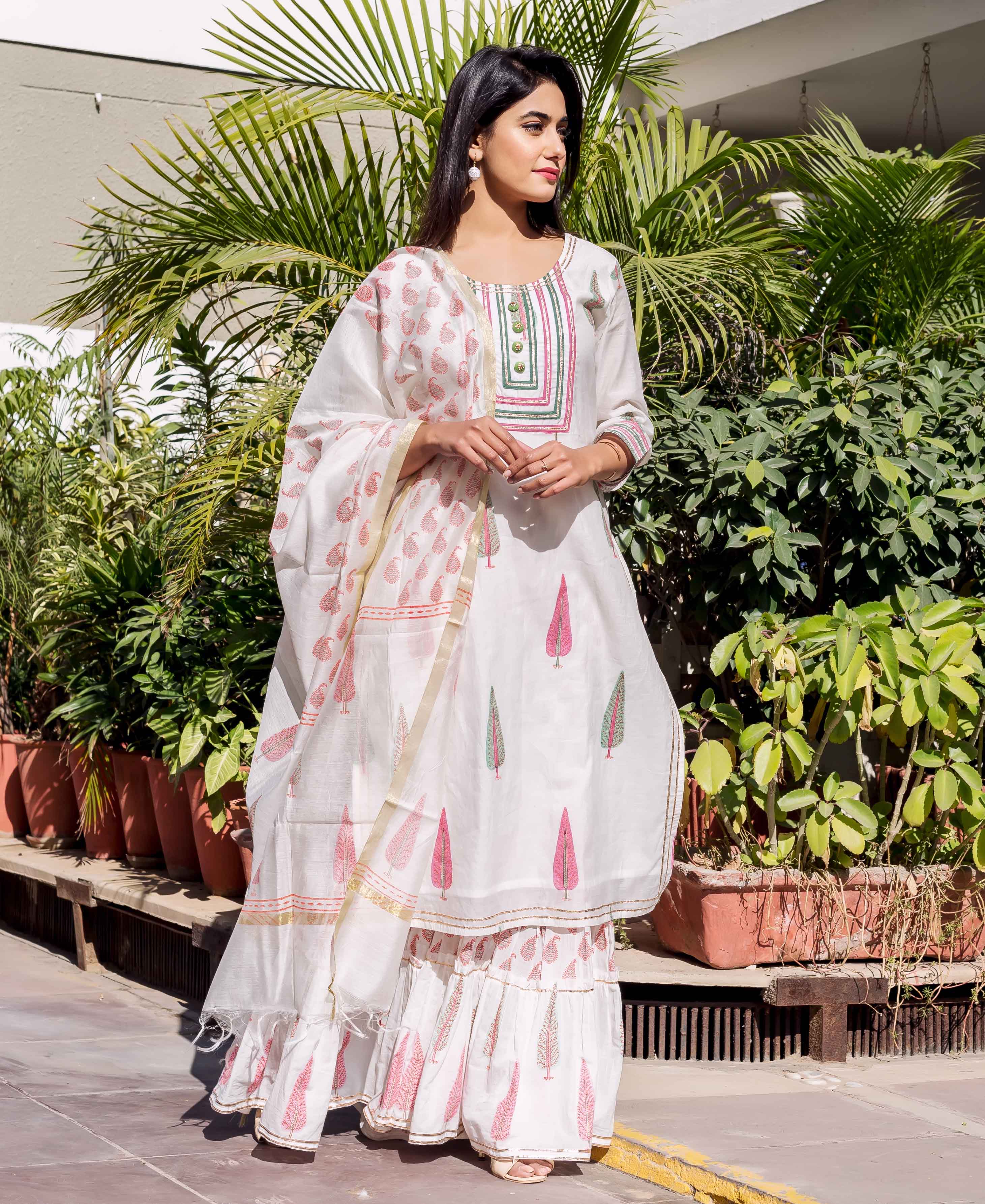 Model wearing white Chanderi kurta set with pink and green leaf block prints.