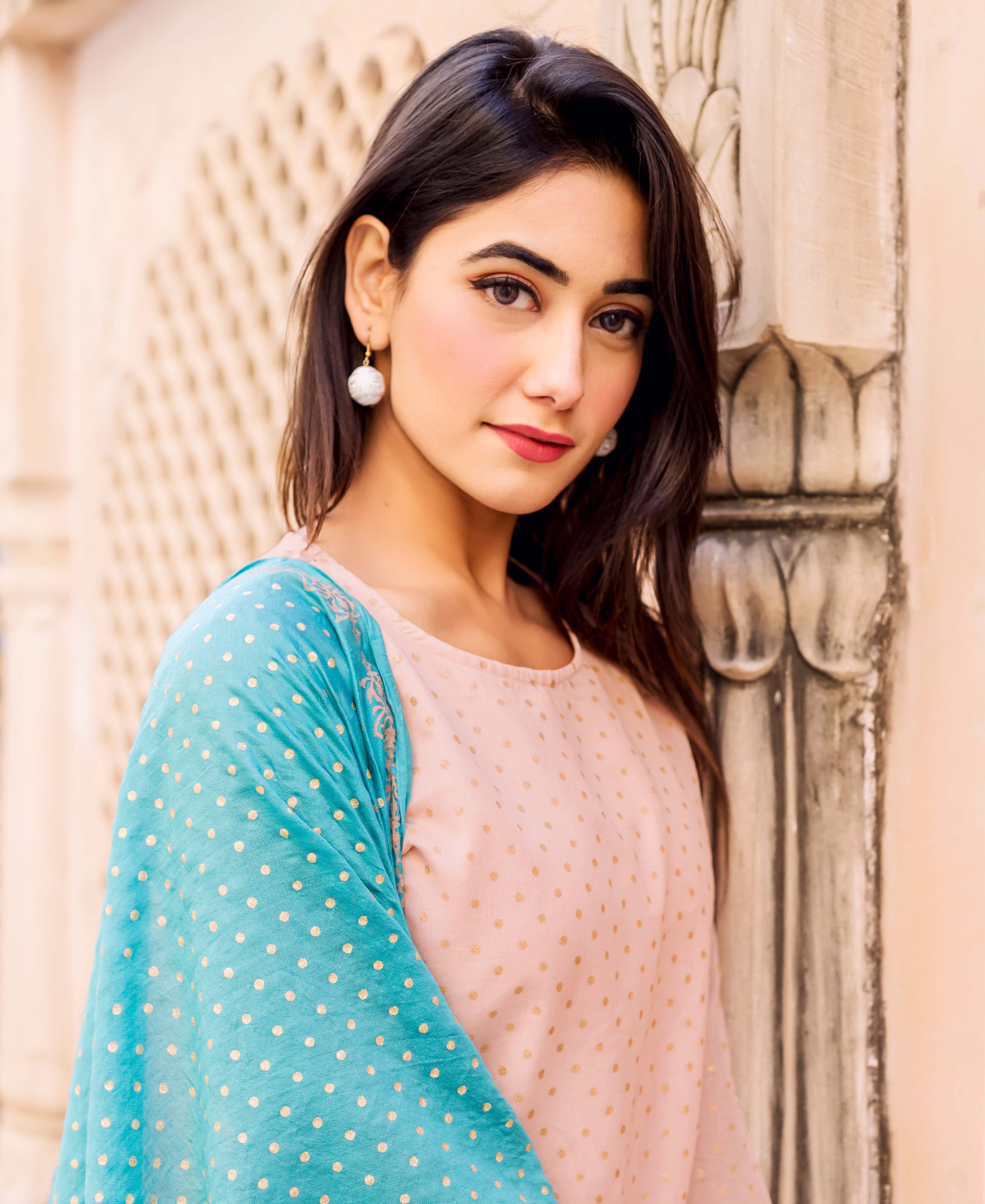 Model wearing a peach polka-dotted kurta with subtle embroidery and a teal polka-dotted dupatta.