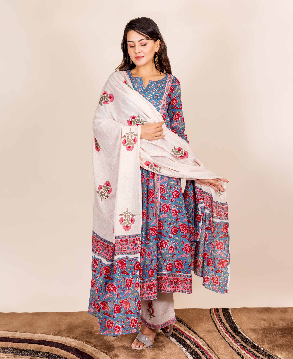 A model wearing a blue and red hand-block-printed kurta with a white dupatta.