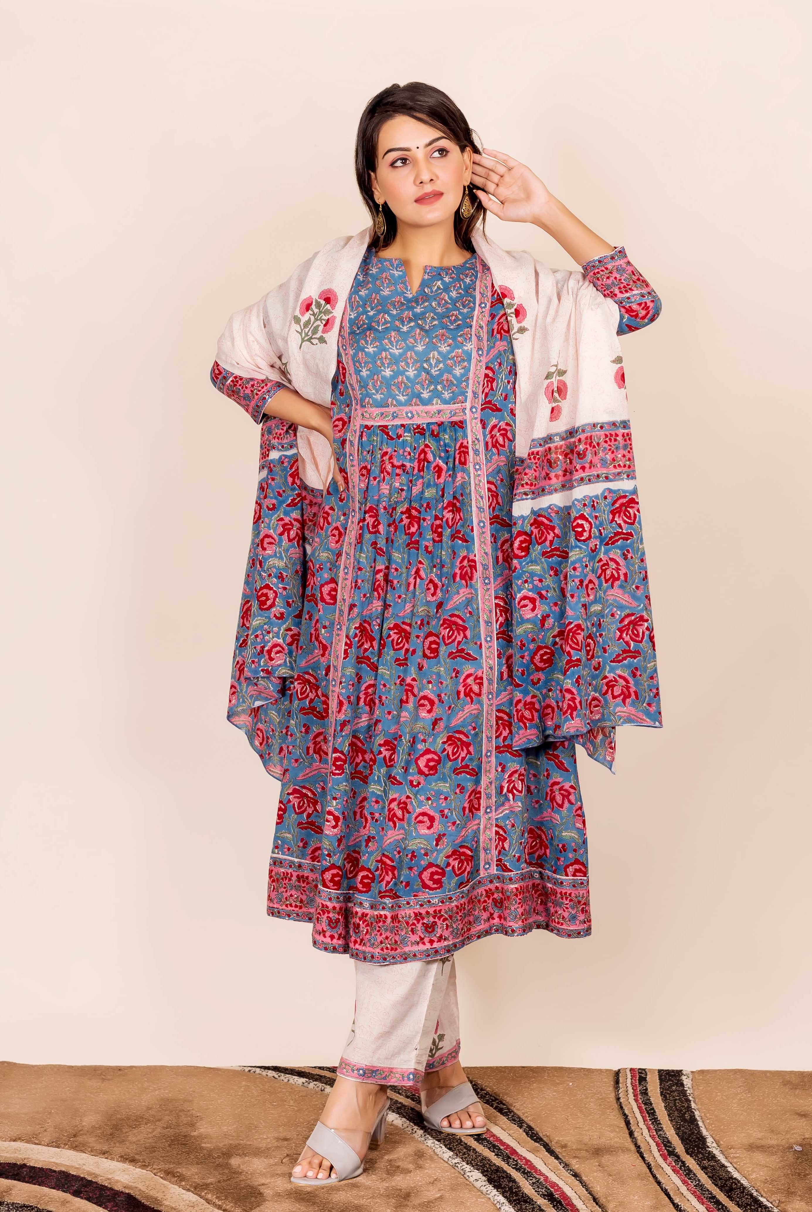 A model wearing a blue and red hand-block-printed kurta with floral patterns.