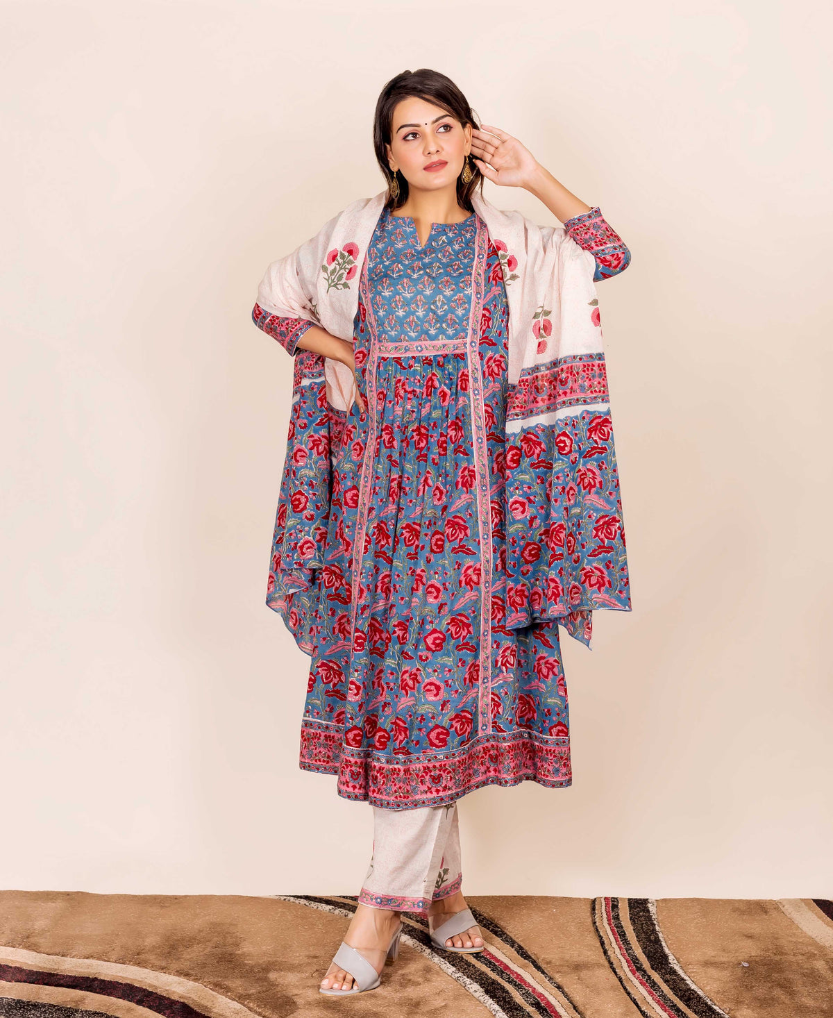 A model wearing a blue and red hand-block-printed kurta with floral patterns.