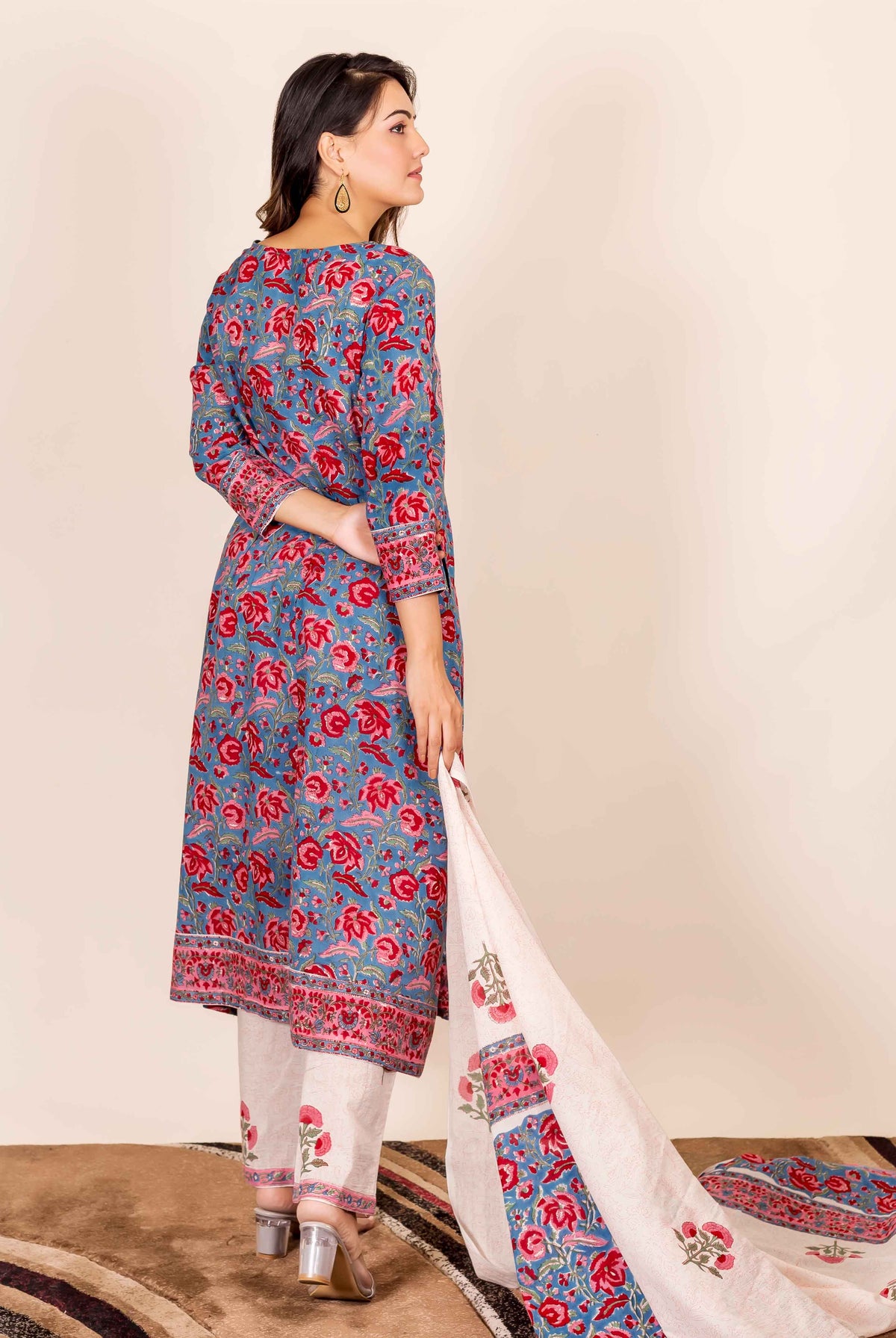 A model wearing a blue and red hand-block-printed kurta with floral patterns.
