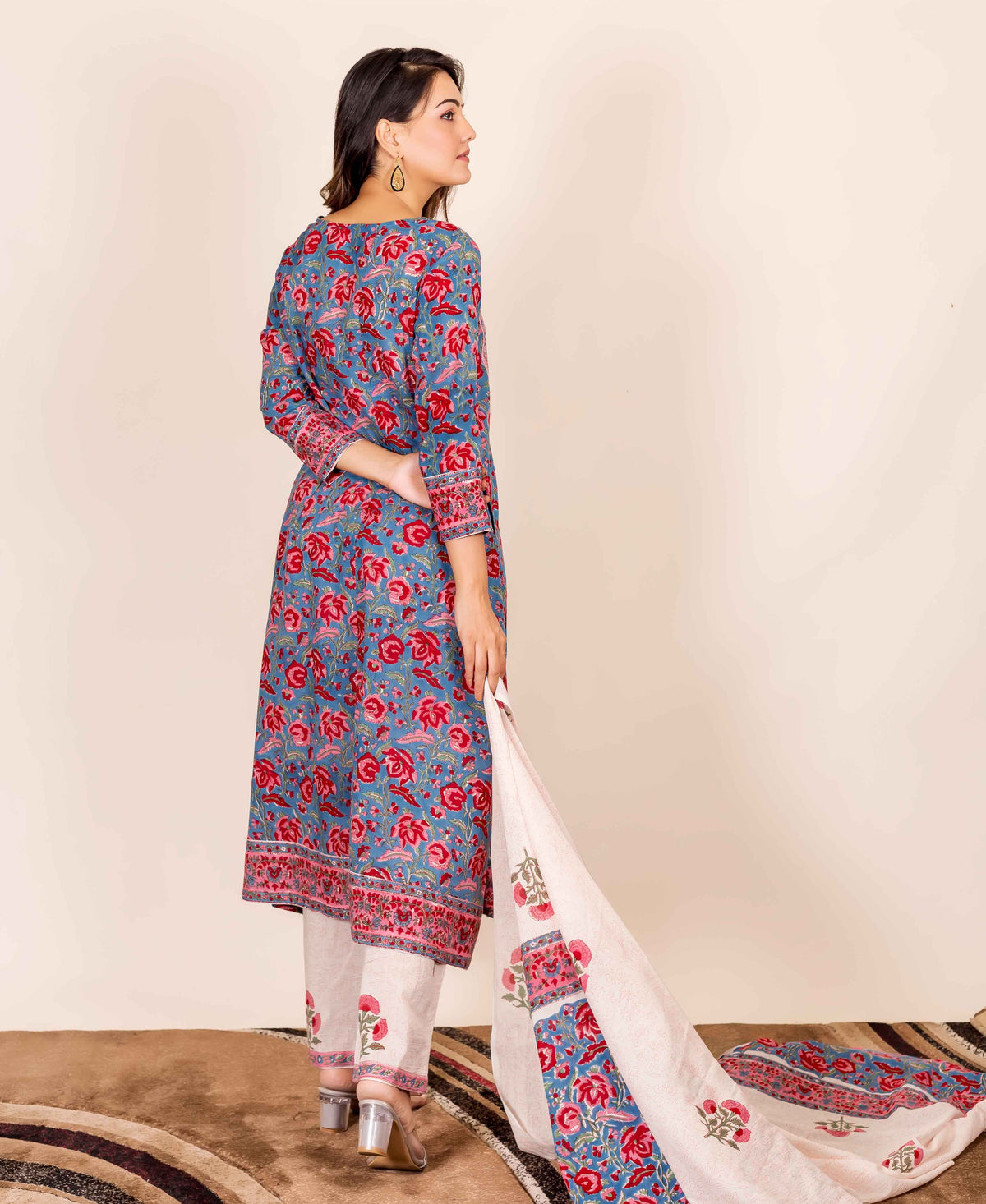 A model wearing a blue and red hand-block-printed kurta with floral patterns.