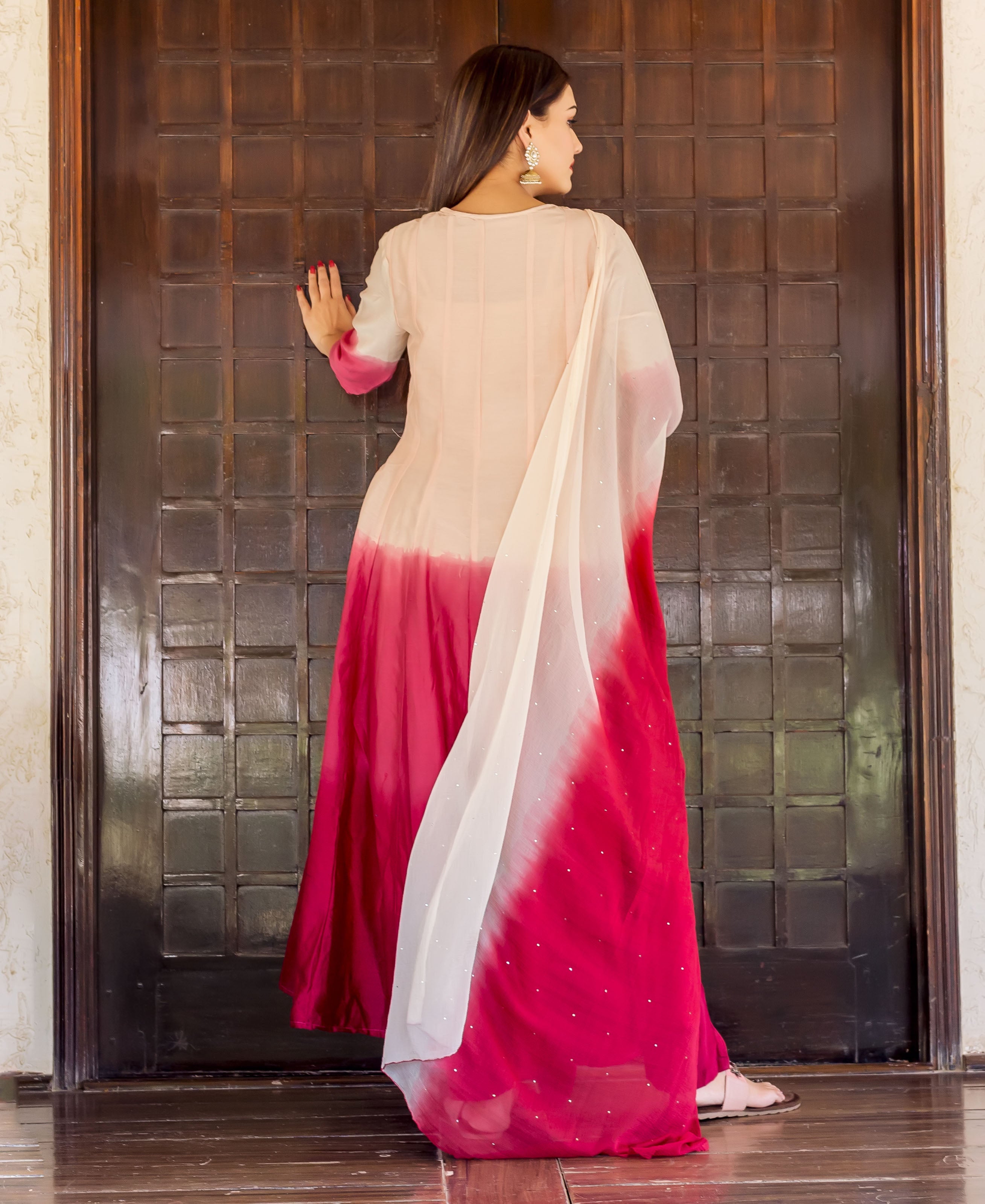 Back view of a model in a salmon-to-burgundy ombre Anarkali kurta with gotta embroidery and dupatta.