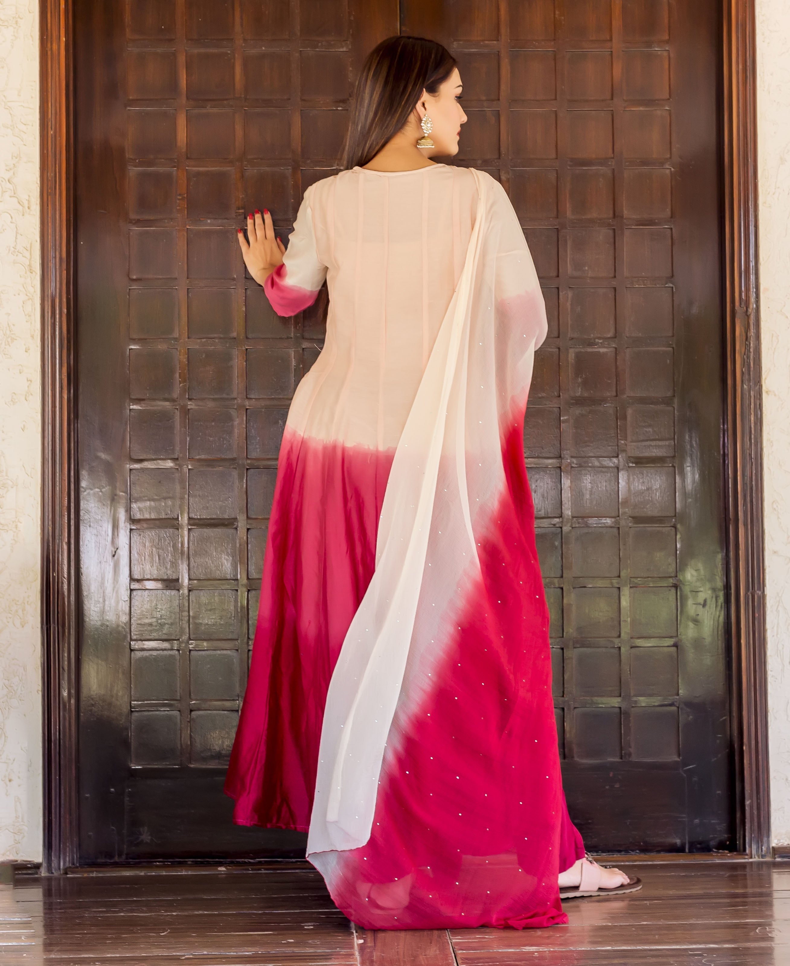 Back view of a model in a salmon-to-burgundy ombre Anarkali kurta with gotta embroidery and dupatta.
