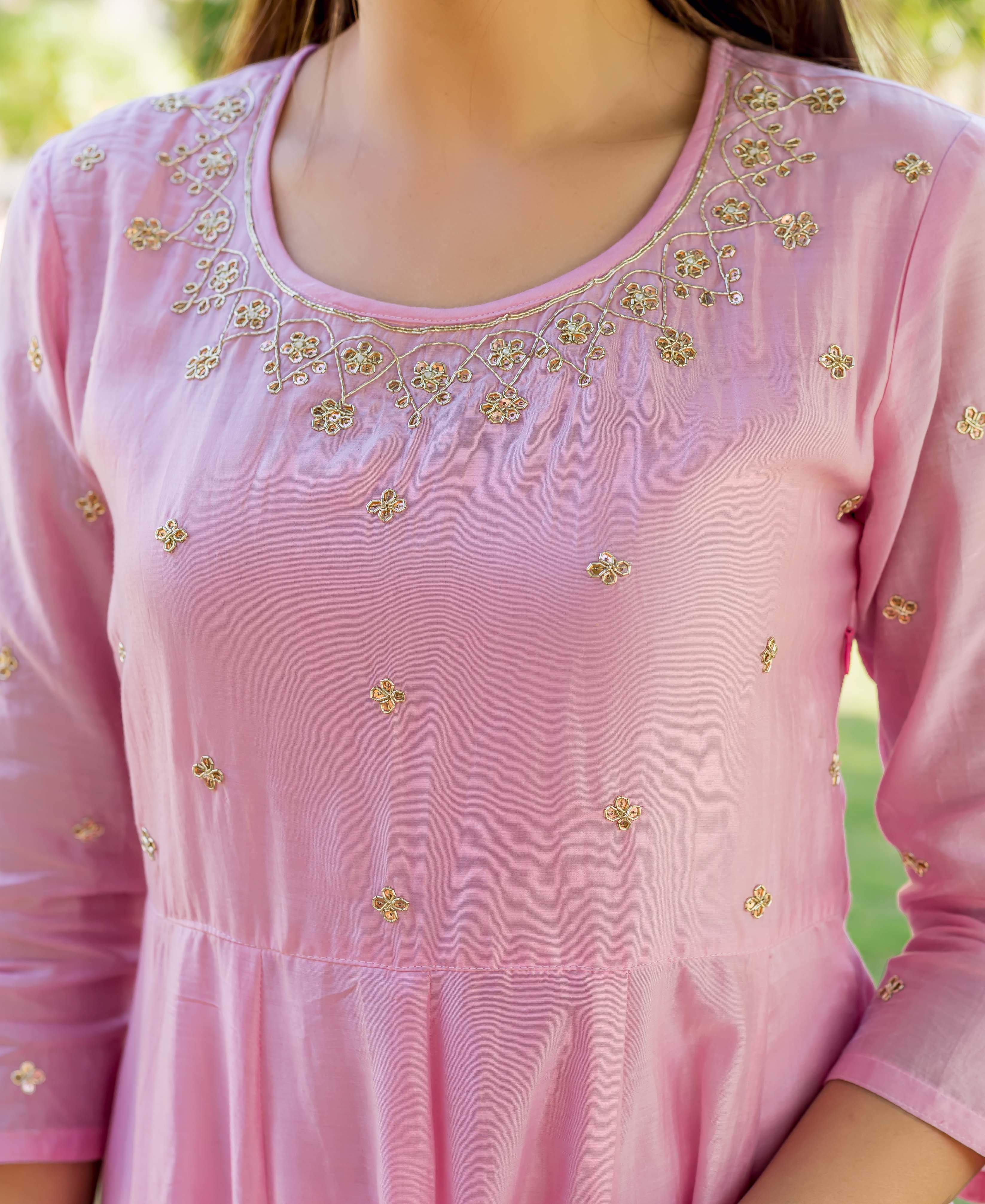 Blush pink embroidered dress with gold floral pattern on a model.