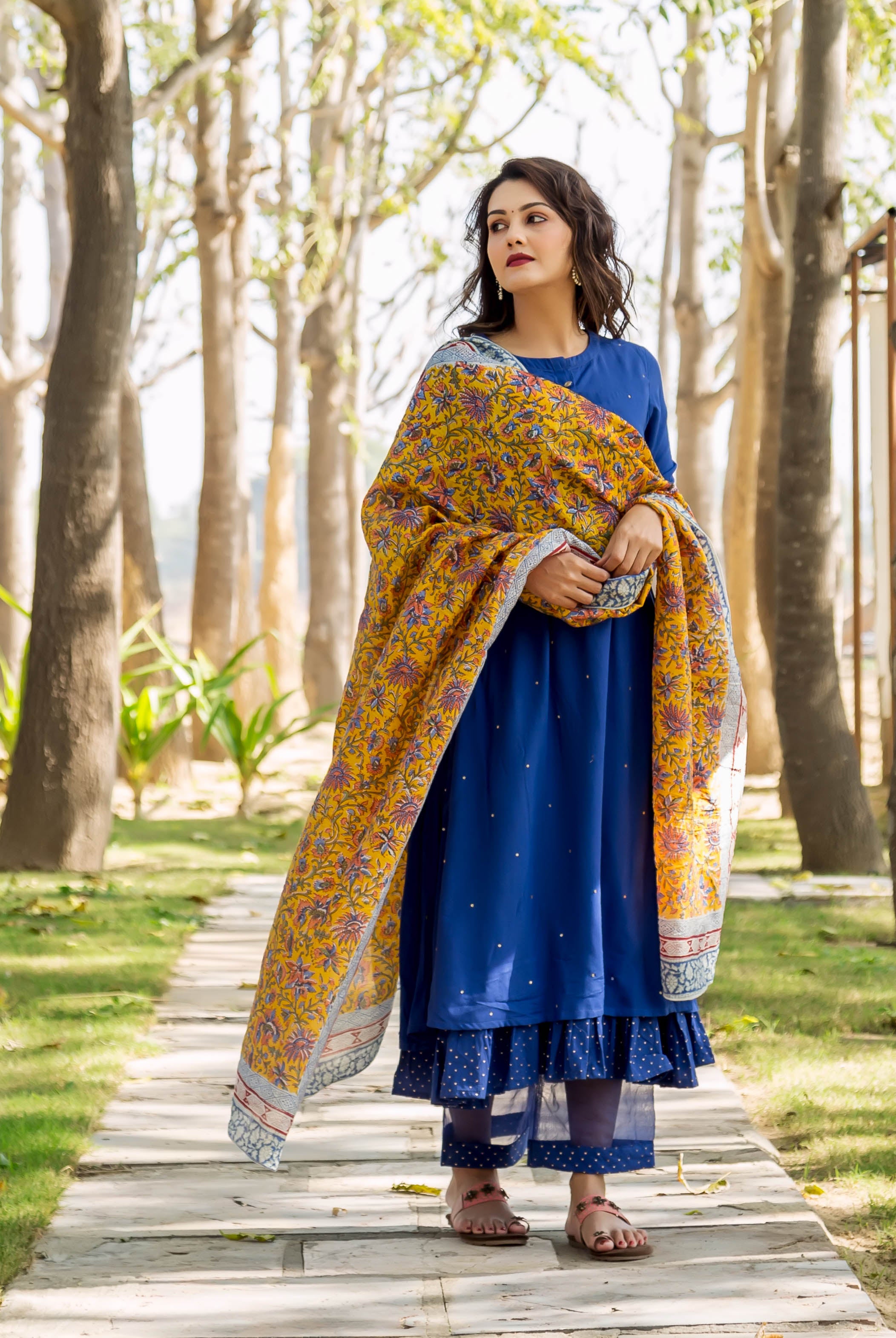 Woman in azure blue embroidered layered kurta with yellow hand-block-printed floral dupatta.