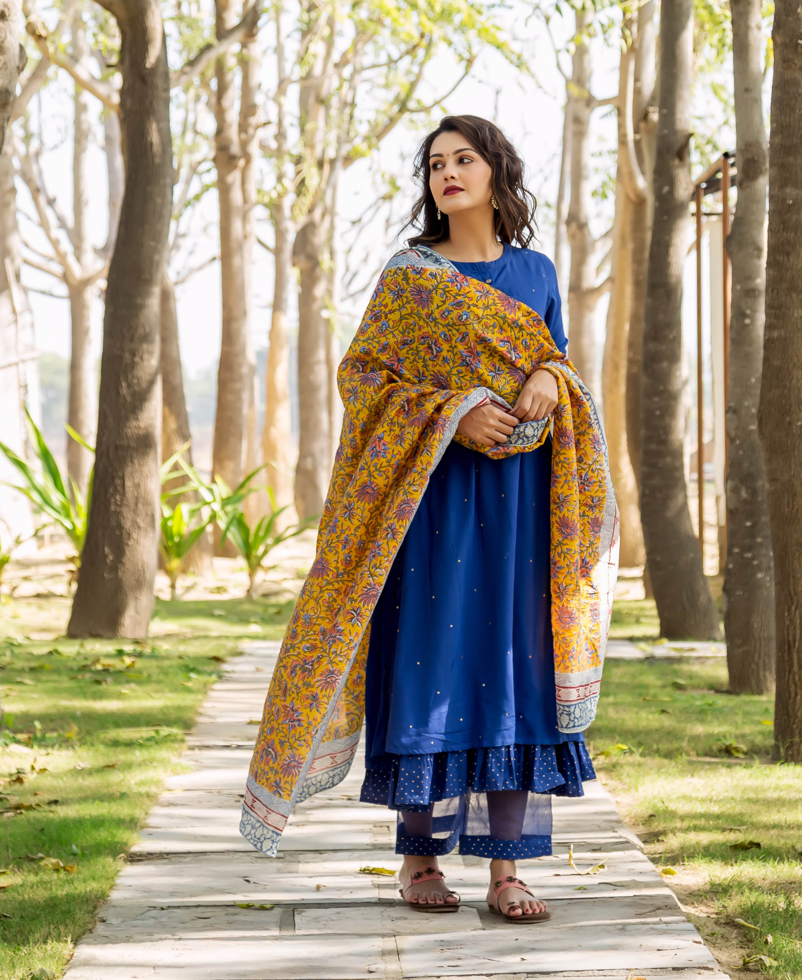 Woman in azure blue embroidered layered kurta with yellow hand-block-printed floral dupatta.
