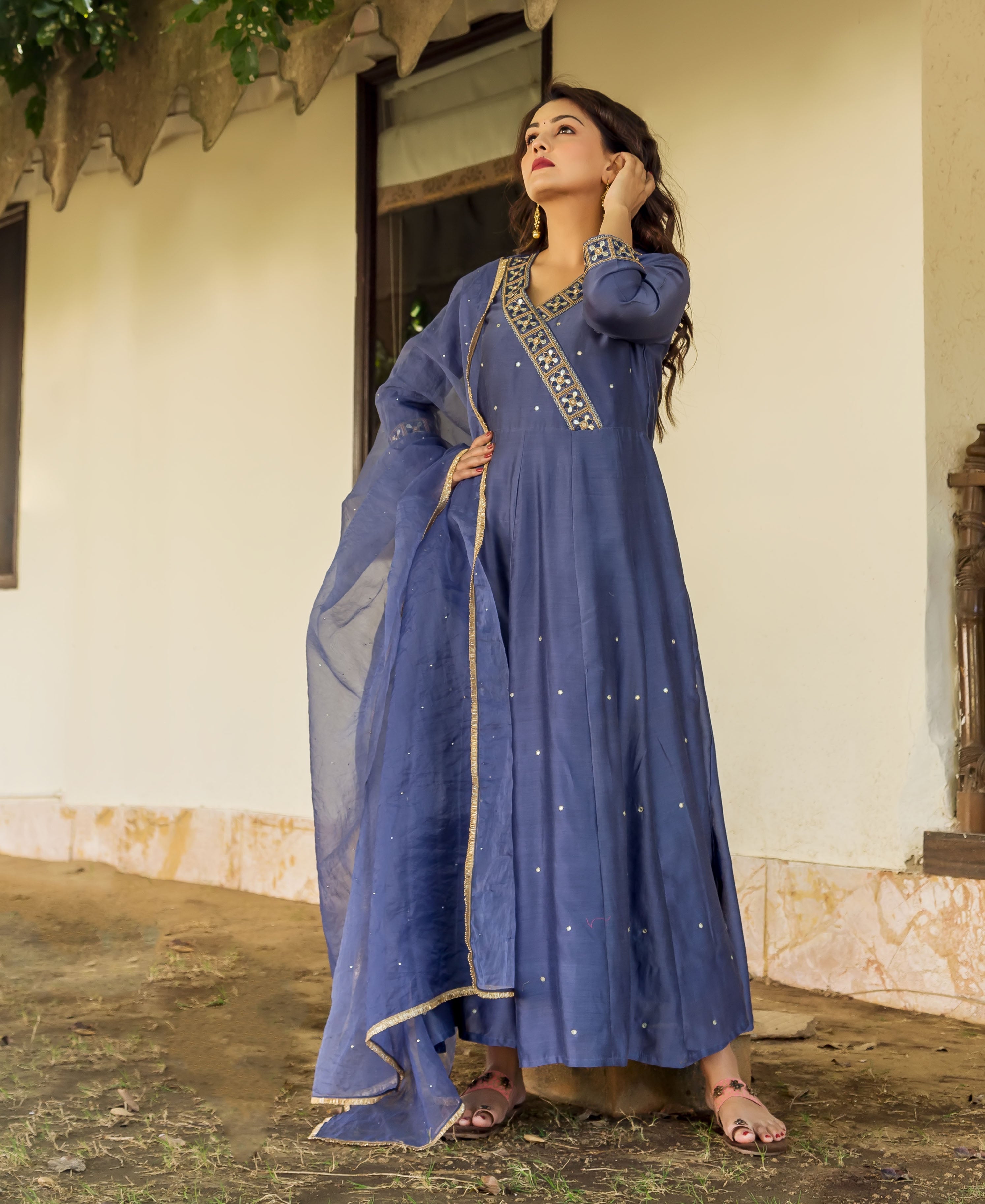 A woman in a steel blue, hand-embroidered Chanderi dress with gold accents.