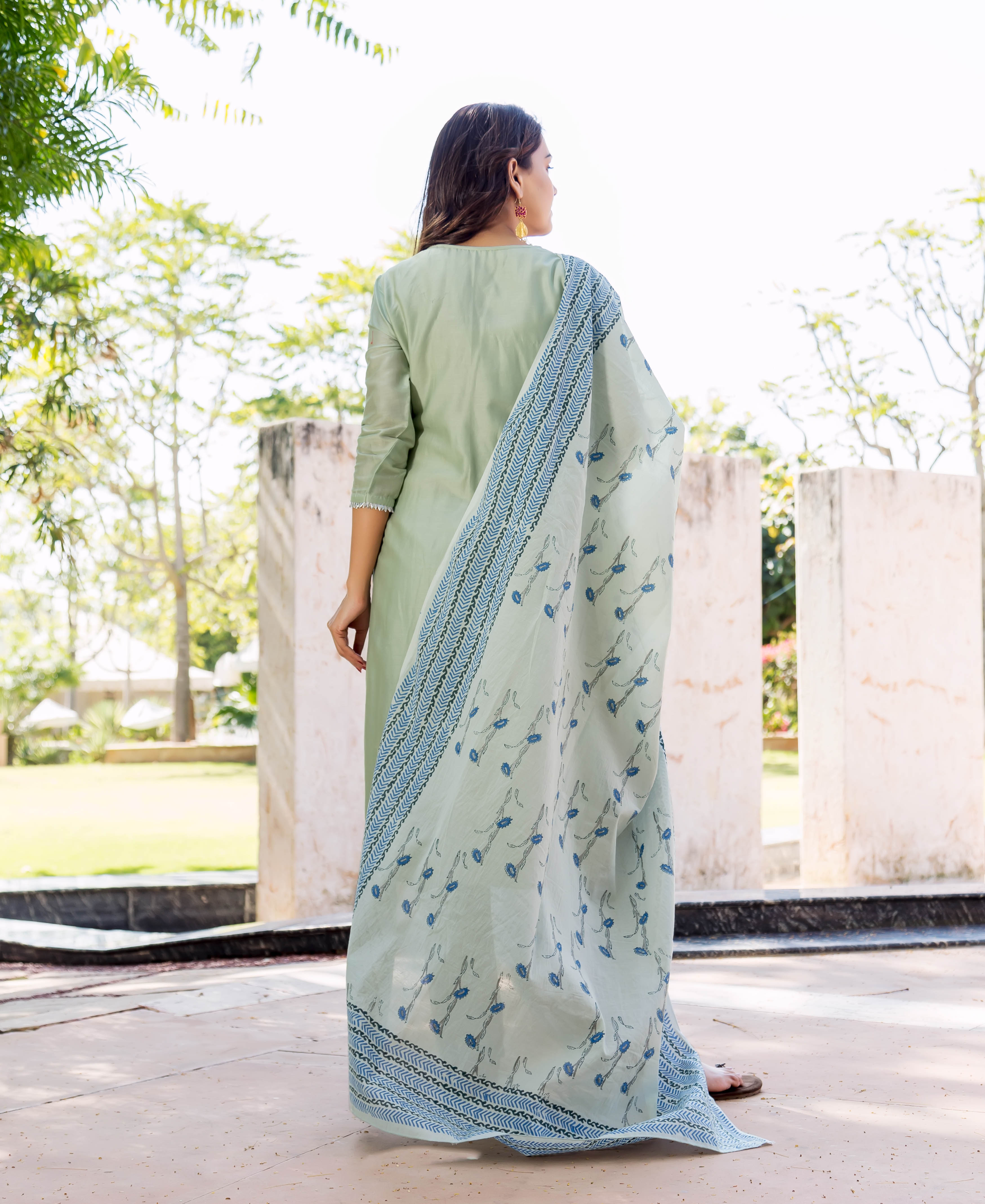 Woman wearing pistachio green kurta with a blue hand-block printed dupatta, seen from back.