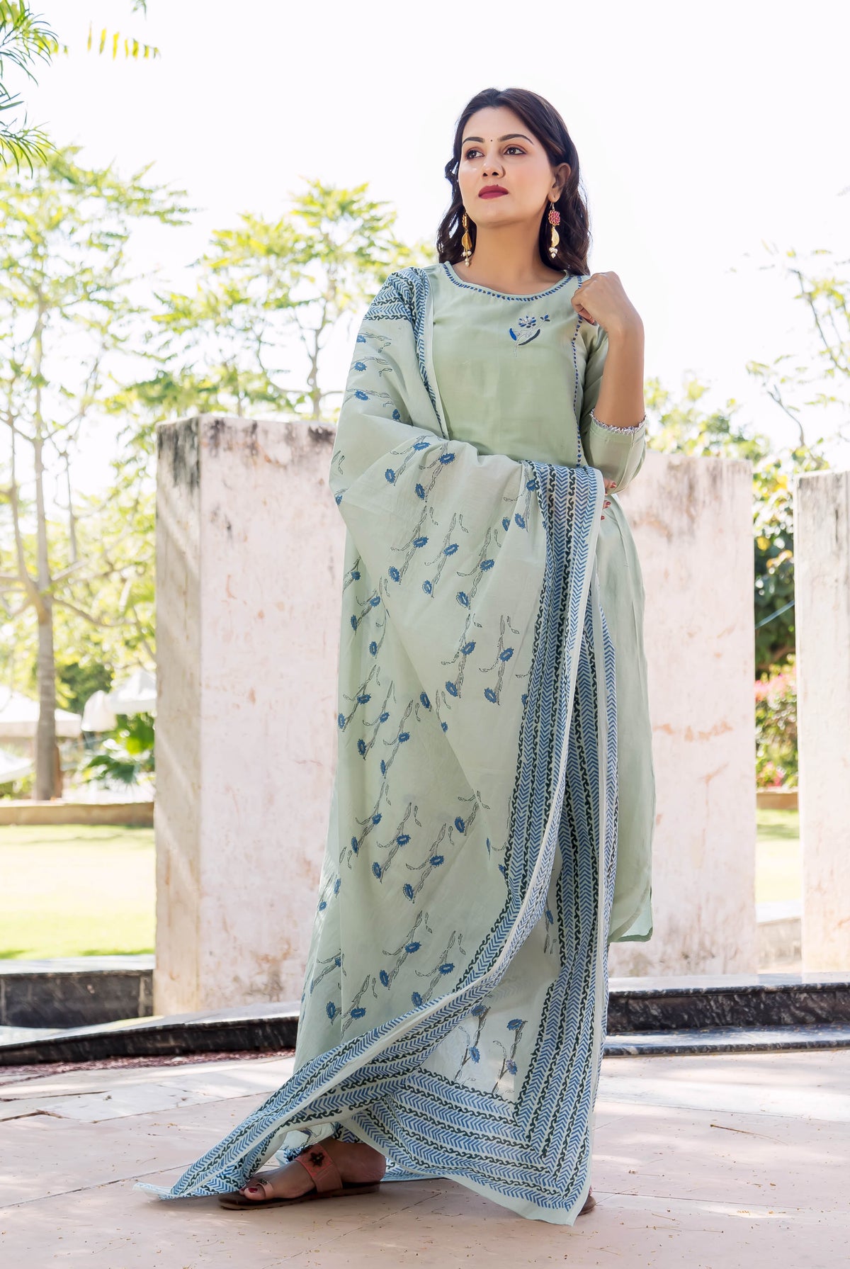 Woman wearing a pistachio green kurta set with a blue hand-block printed dupatta, outdoors.