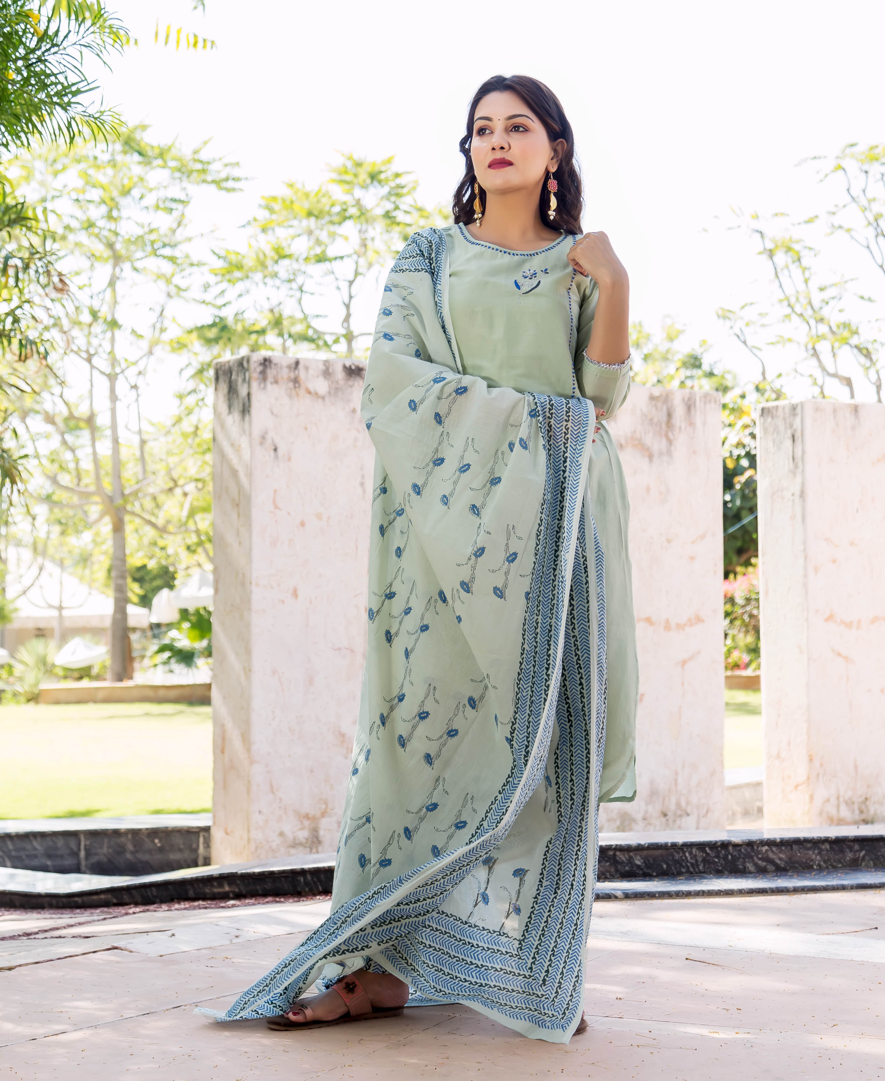 Woman wearing a pistachio green kurta set with a blue hand-block printed dupatta, outdoors.
