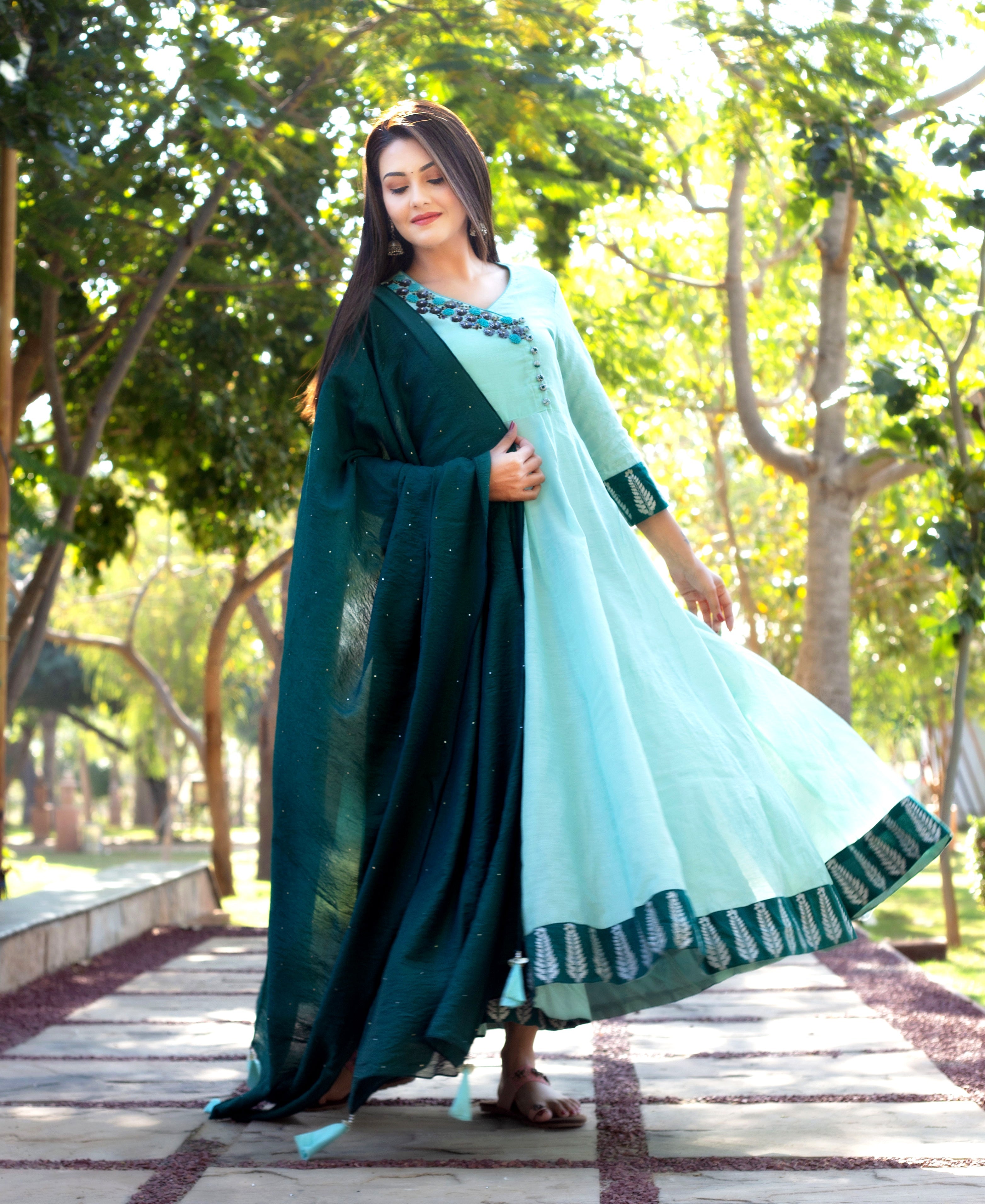 Model wears mint green Angrakha dress with embroidered neckline and hand-block-printed leaf border.