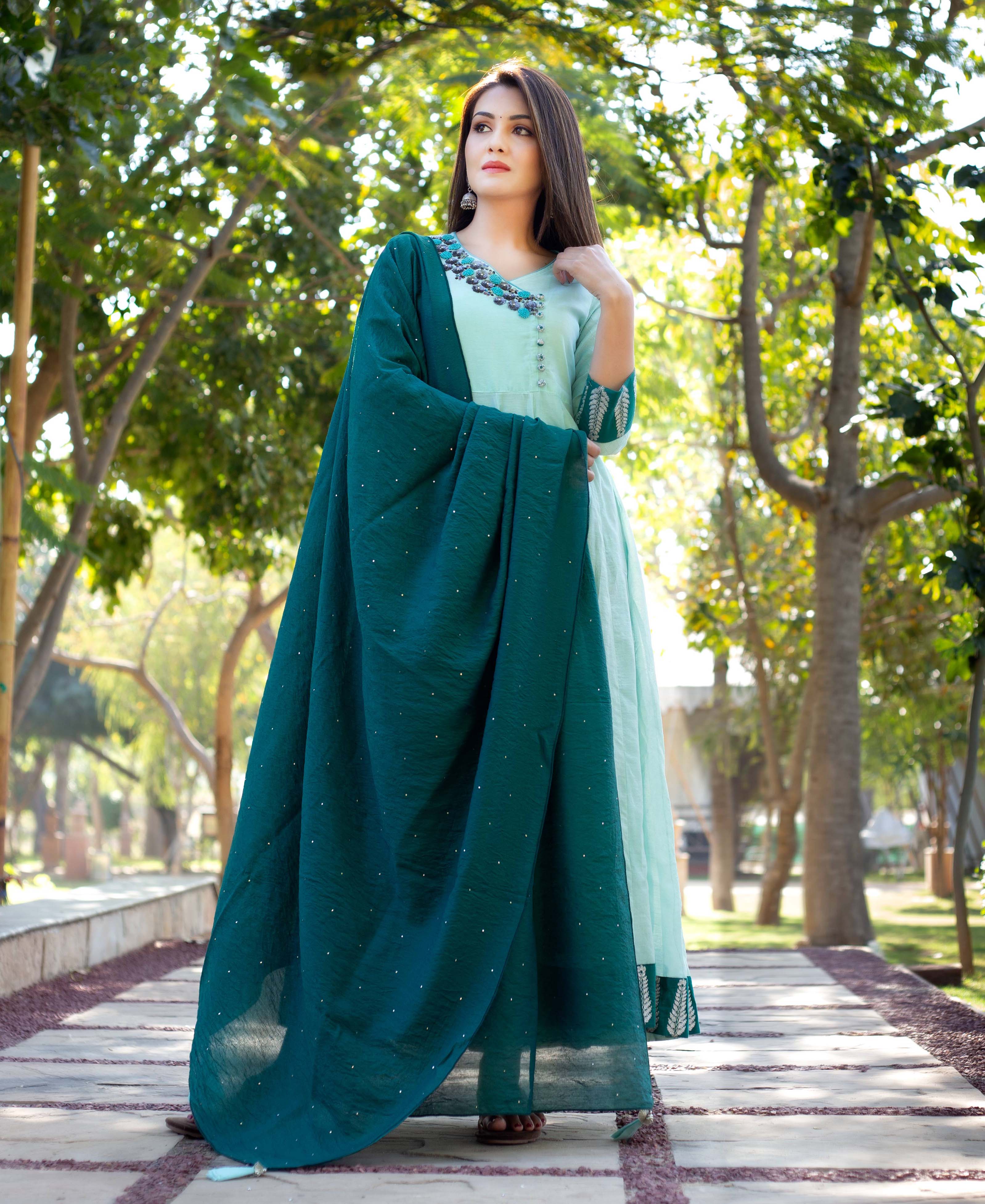 Model wears a mint green Angrakha dress, hand-embroidered, with a dark teal embellished dupatta.
