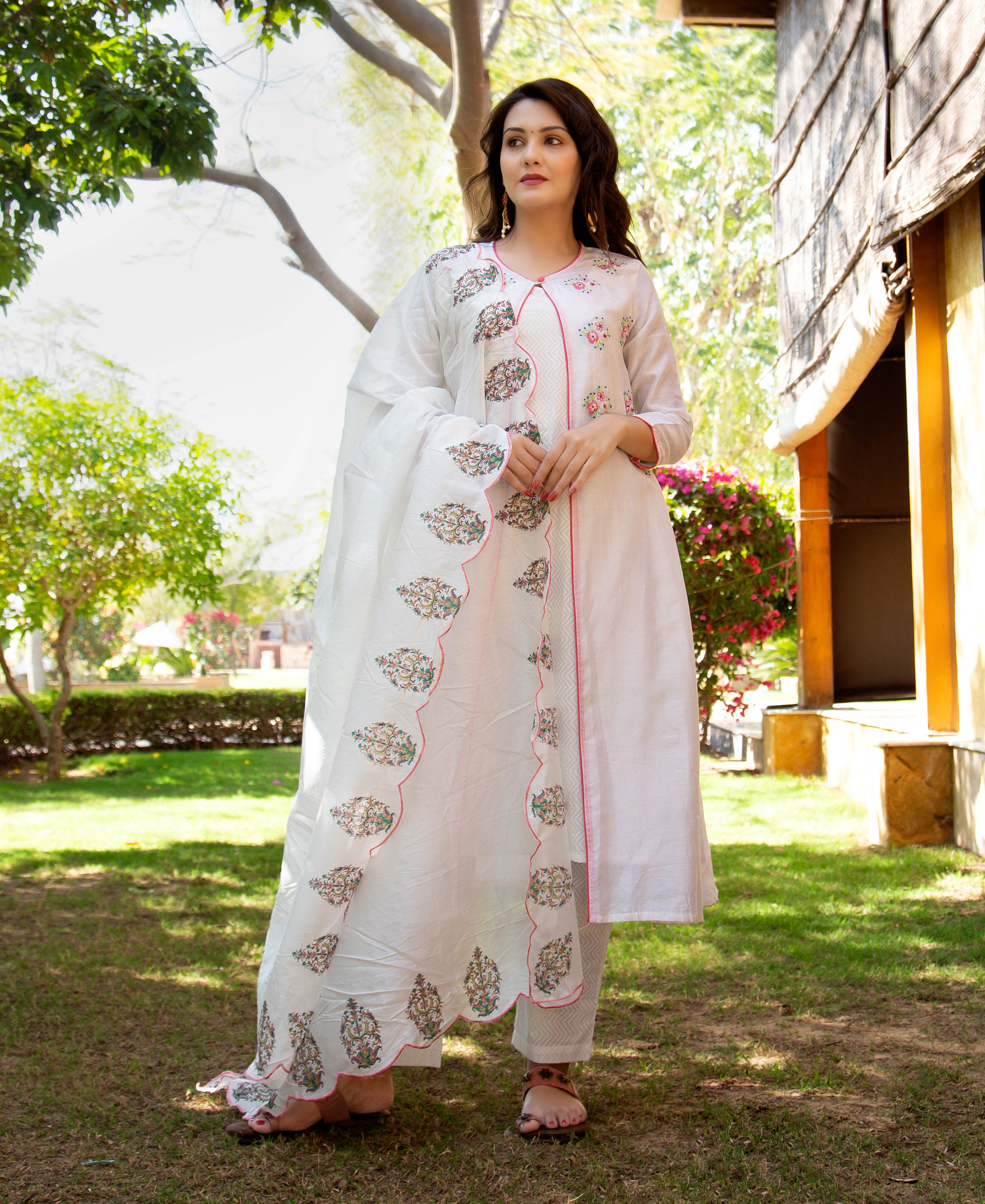 Full-length model in white hand-embroidered kurta set, scalloped block-printed dupatta with ethnic motifs.