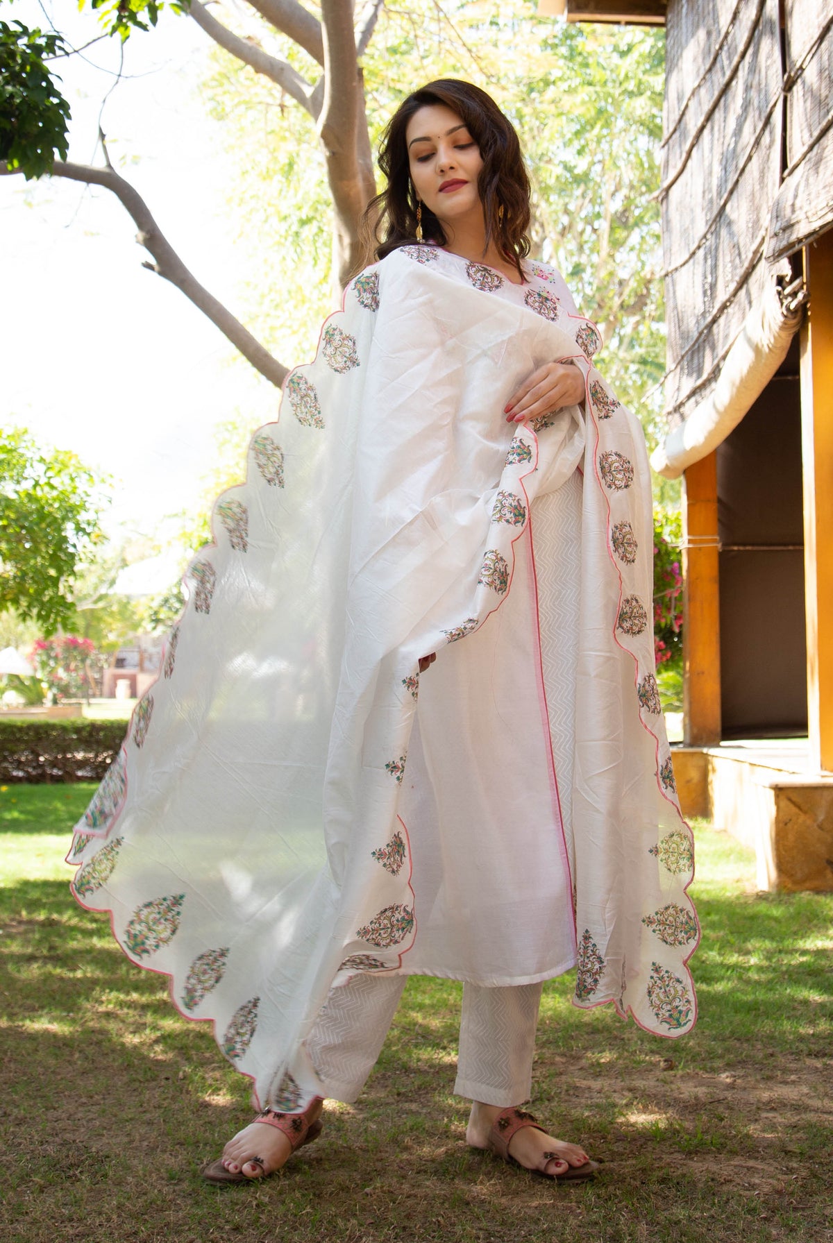 Full-length shot of a model wearing a white kurta set with a hand-block-printed scalloped dupatta.