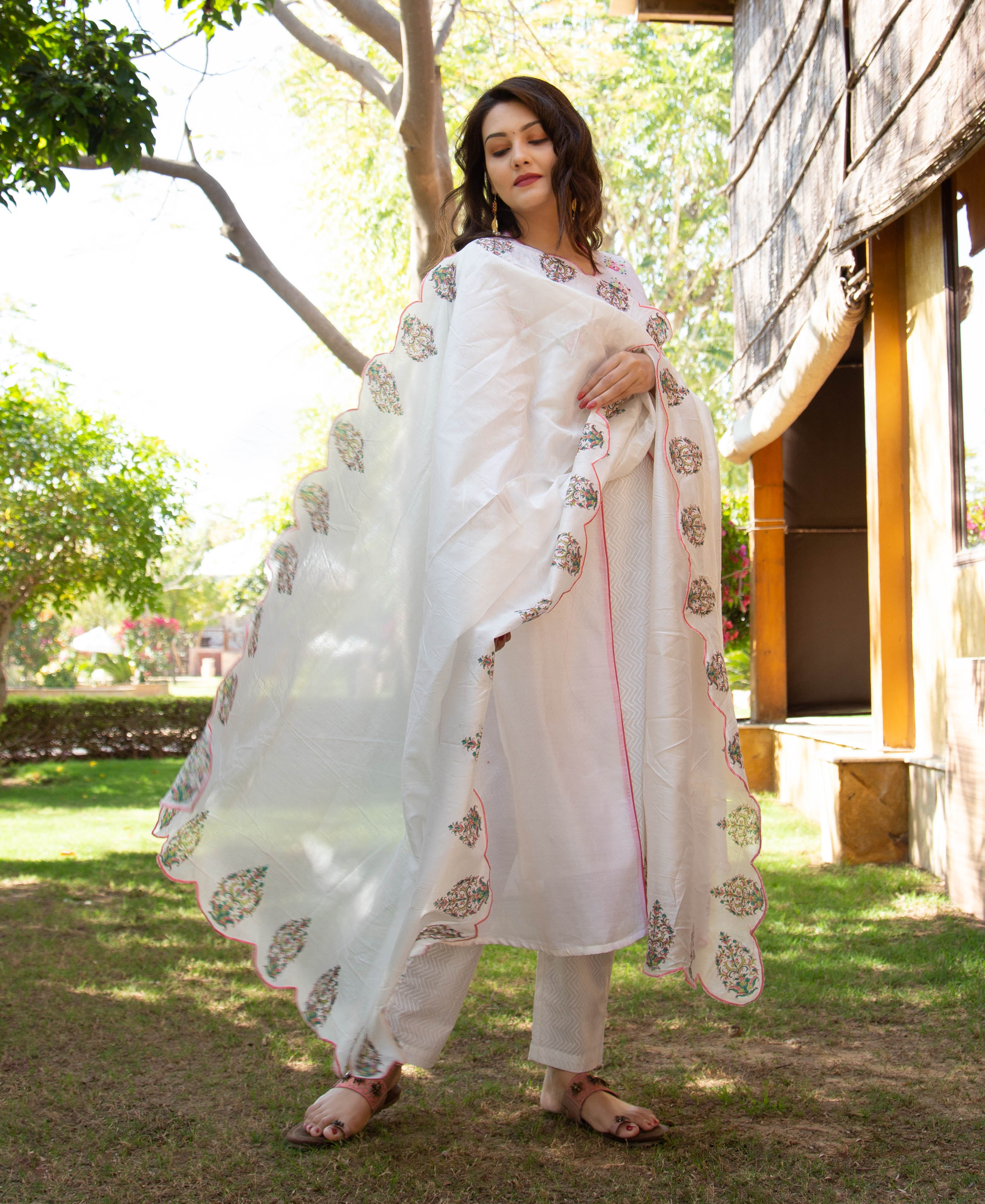 Full-length shot of a model wearing a white kurta set with a hand-block-printed scalloped dupatta.
