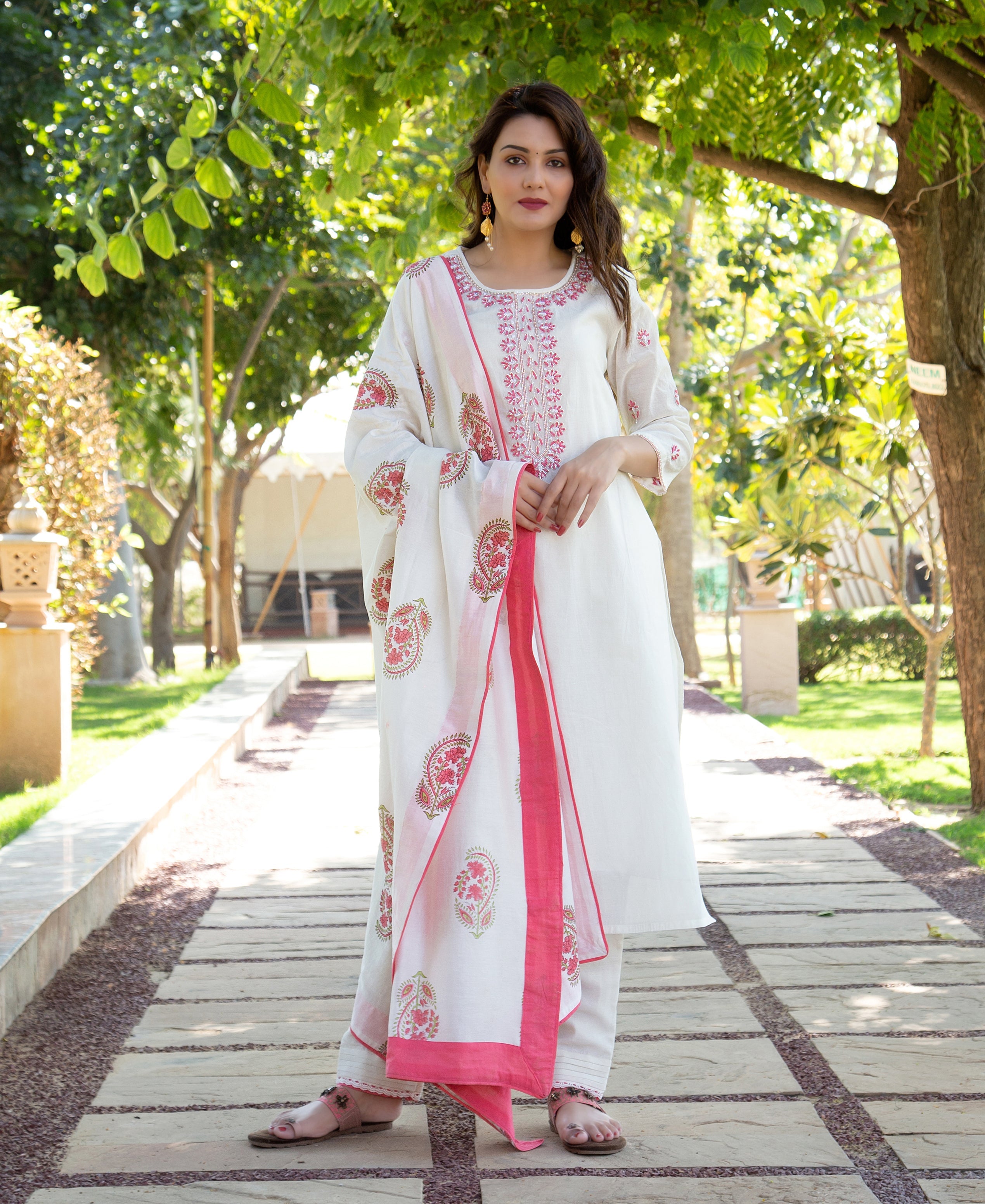 Model in white kurta with pink embroidered neckline and matching floral block-printed dupatta.
