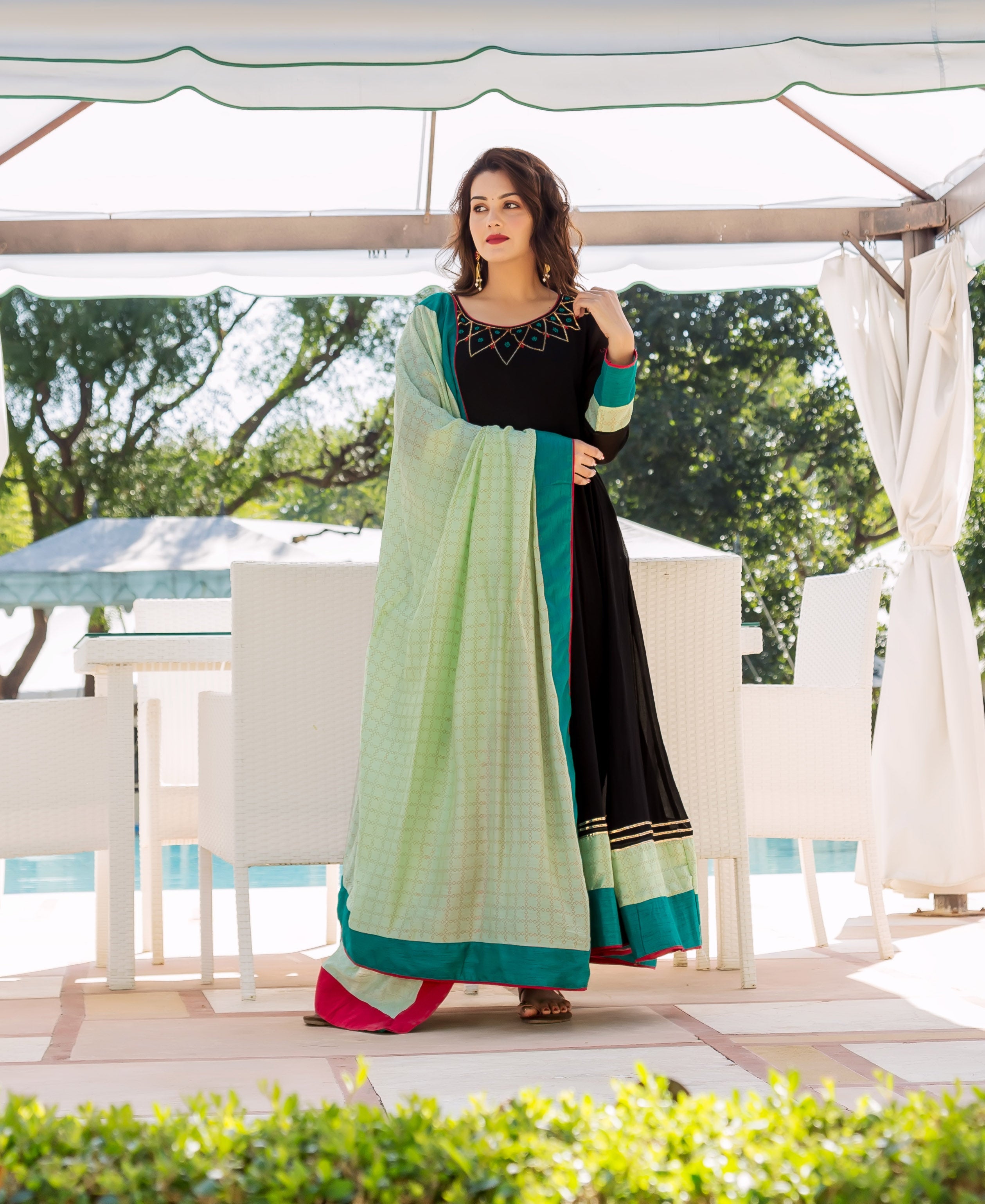 Black Anarkali dress on model, with patterned yoke, lime green dupatta, and teal trim.