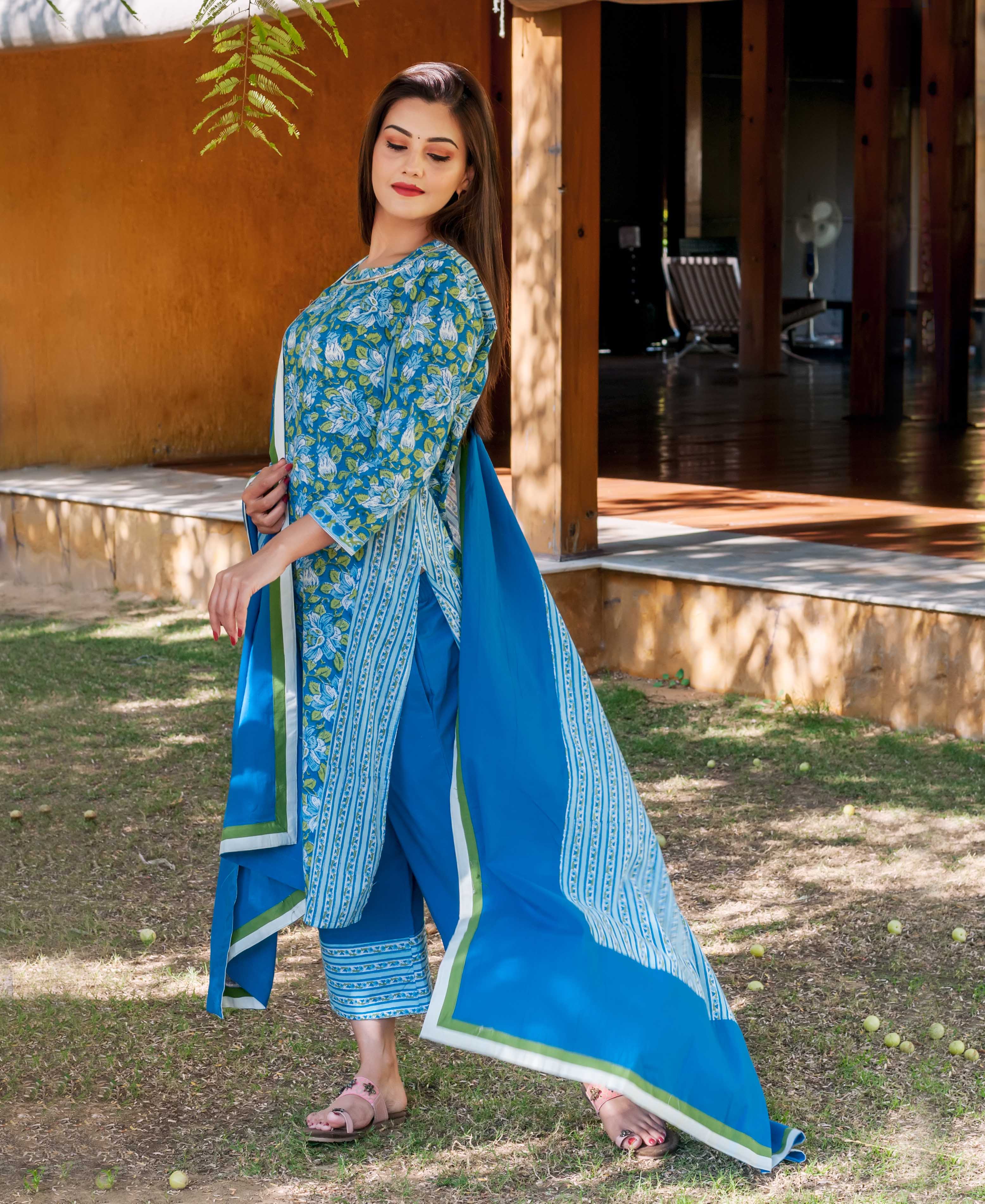 Woman in sapphire blue hand-block printed floral kurta set with matching pants and dupatta.