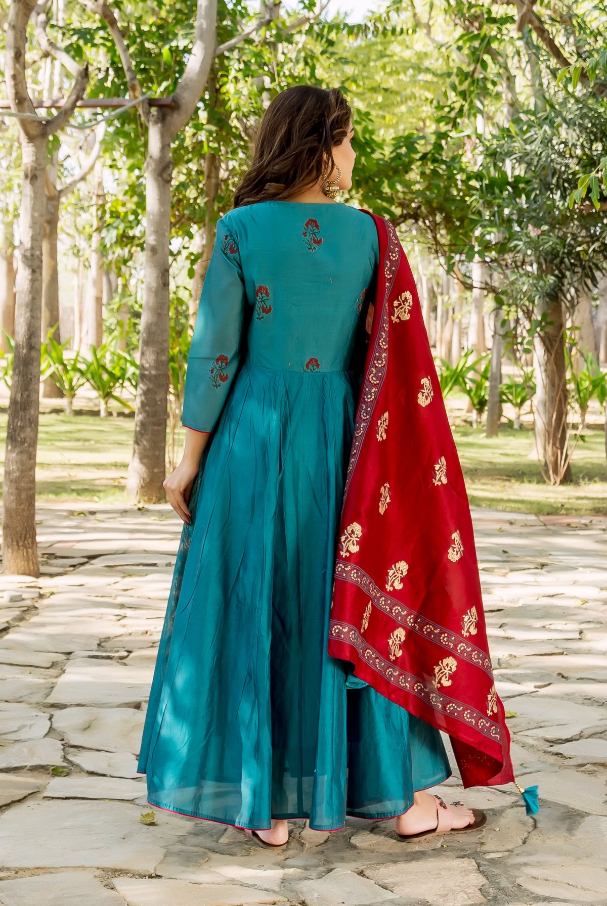 Back view of model in teal blue floral kurta and a red patterned dupatta.