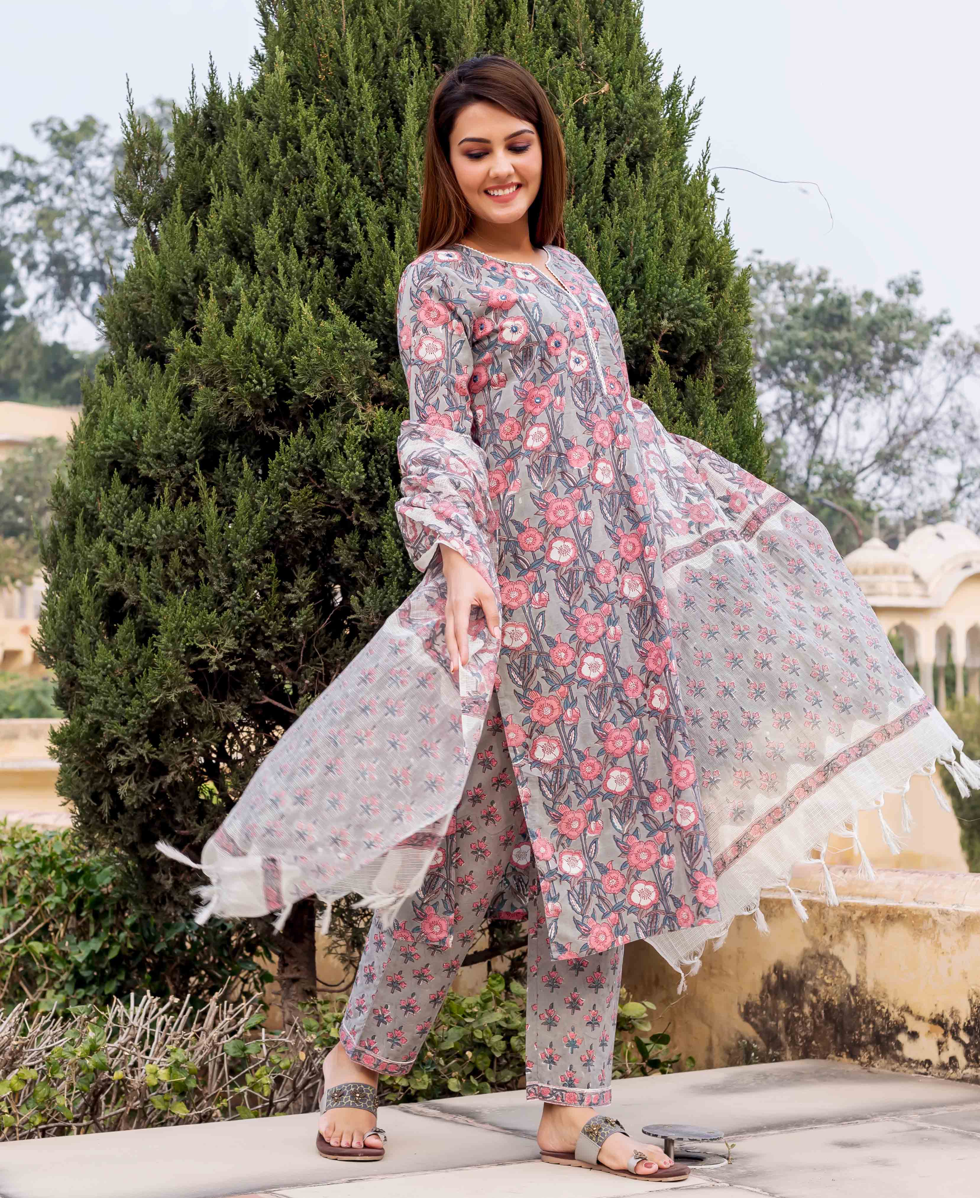 Model in grey and pink hand block printed floral kurta, pants, and flowing dupatta.