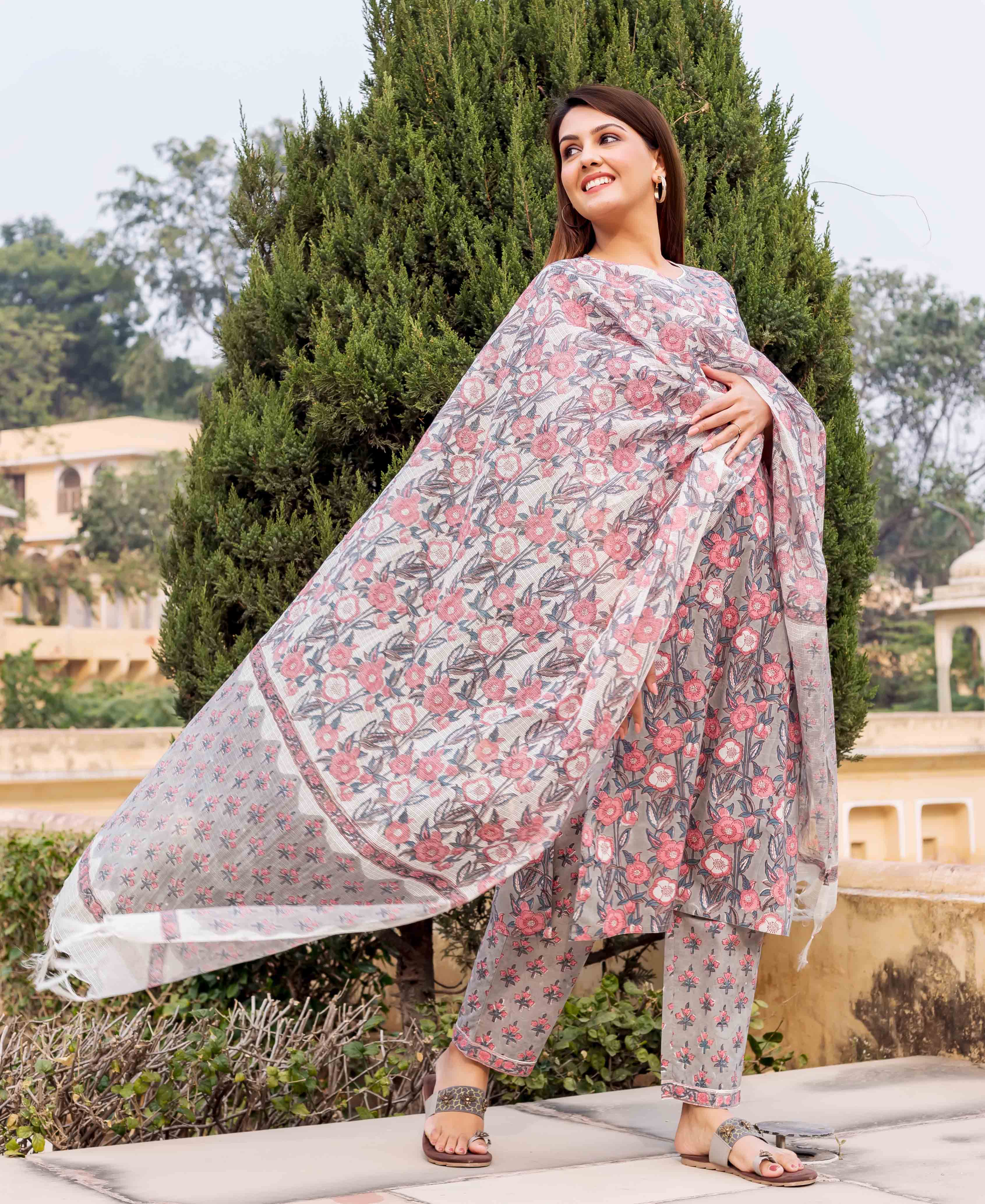 Full-length model in a grey and pink hand block printed floral kurta set with flowing dupatta.