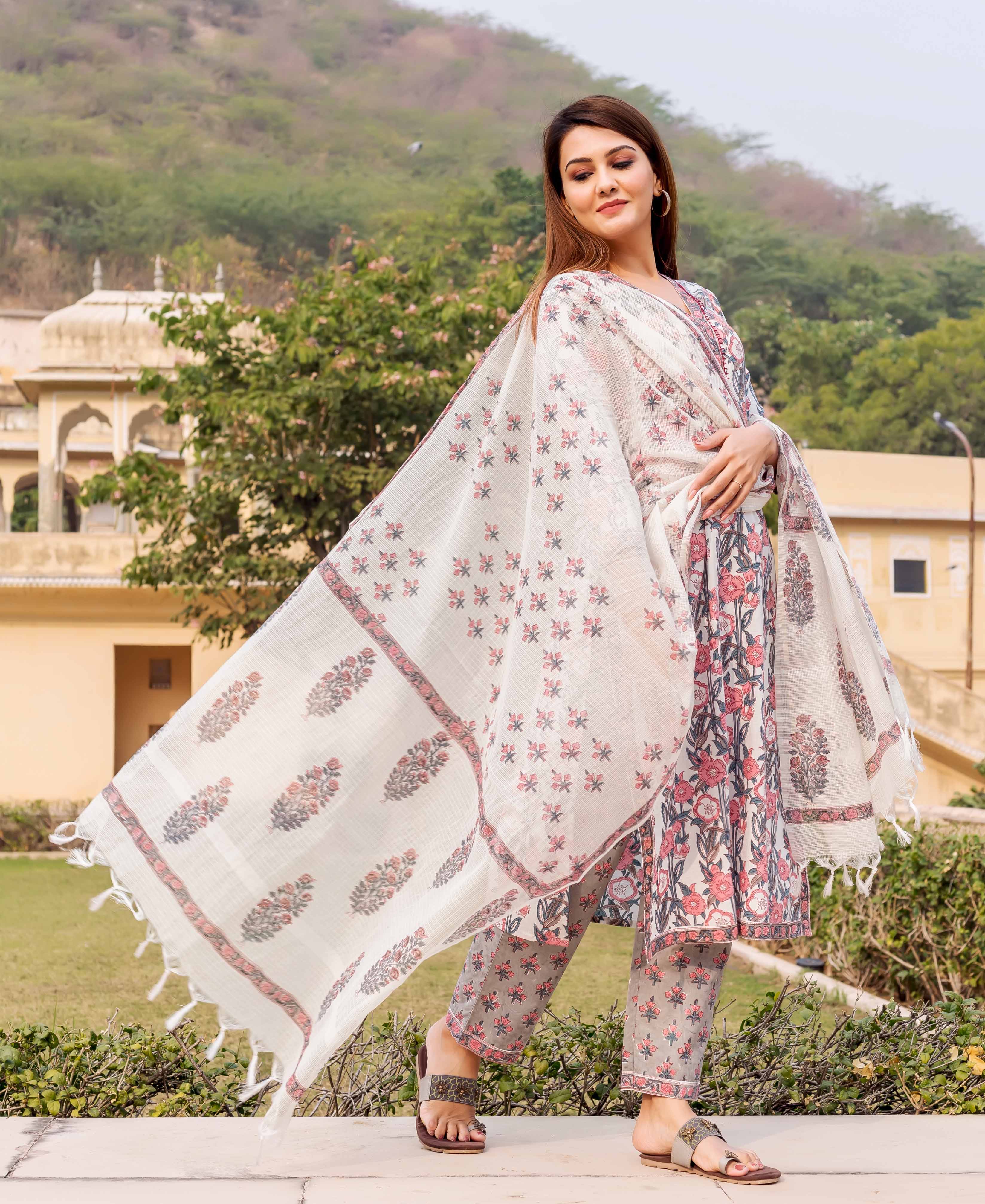 Model in white, pink, grey floral hand block printed kurta, pants, and flowing dupatta.