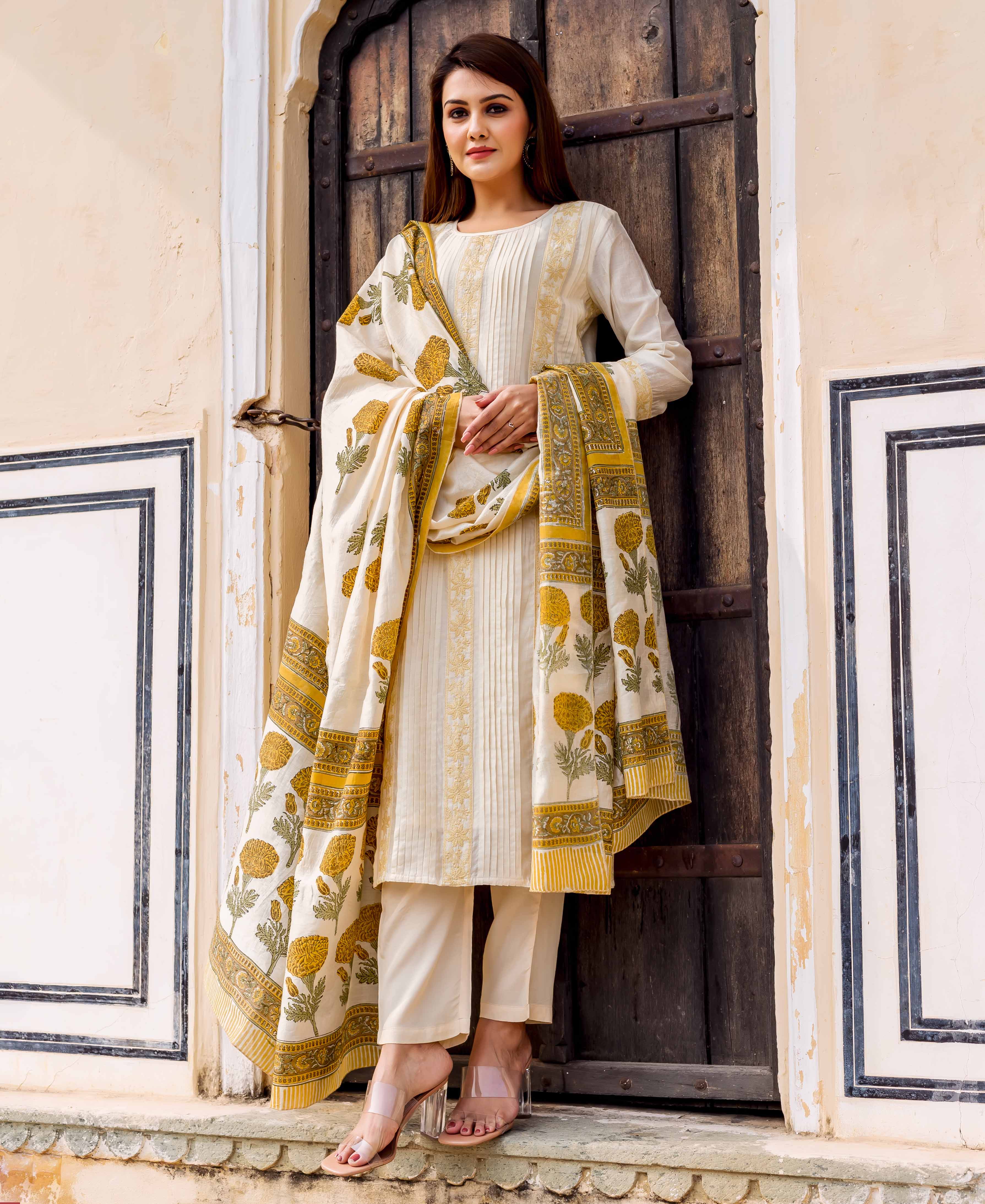 Full-length model in cream straight kurta, block printed with yellow florals and embroidery.