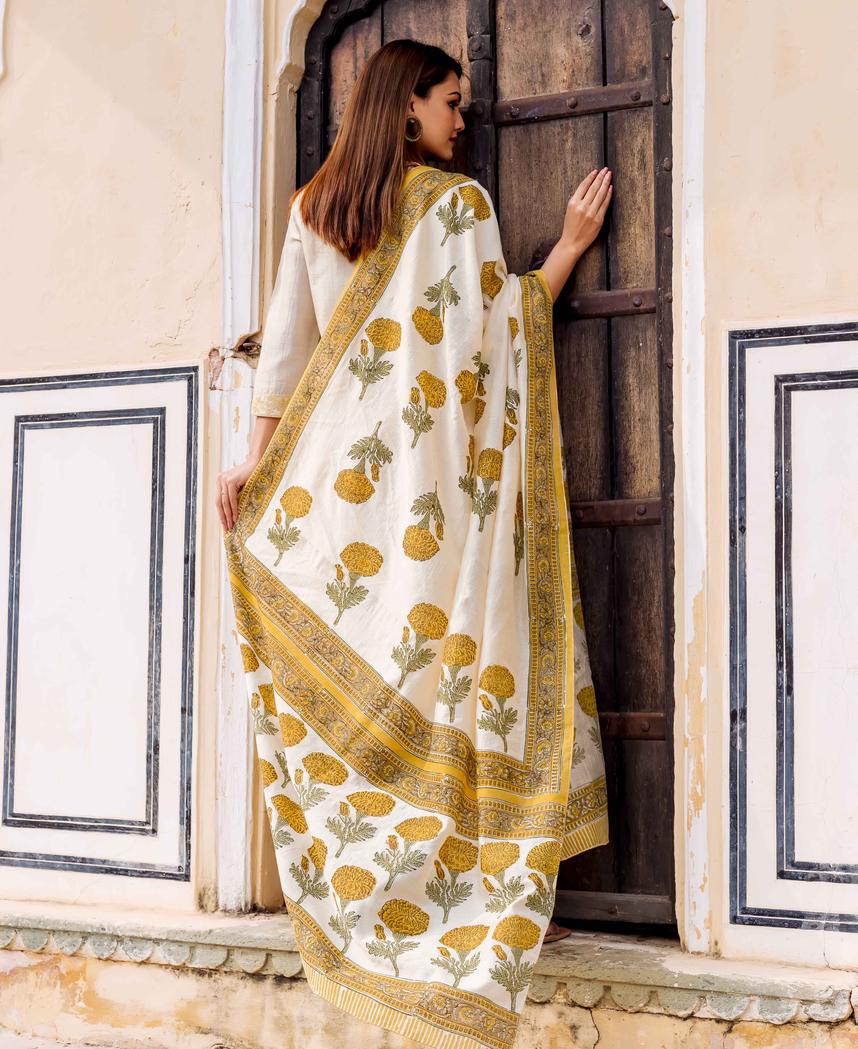 Woman from behind wearing a cream kurta, draped with yellow floral hand-block printed fabric.