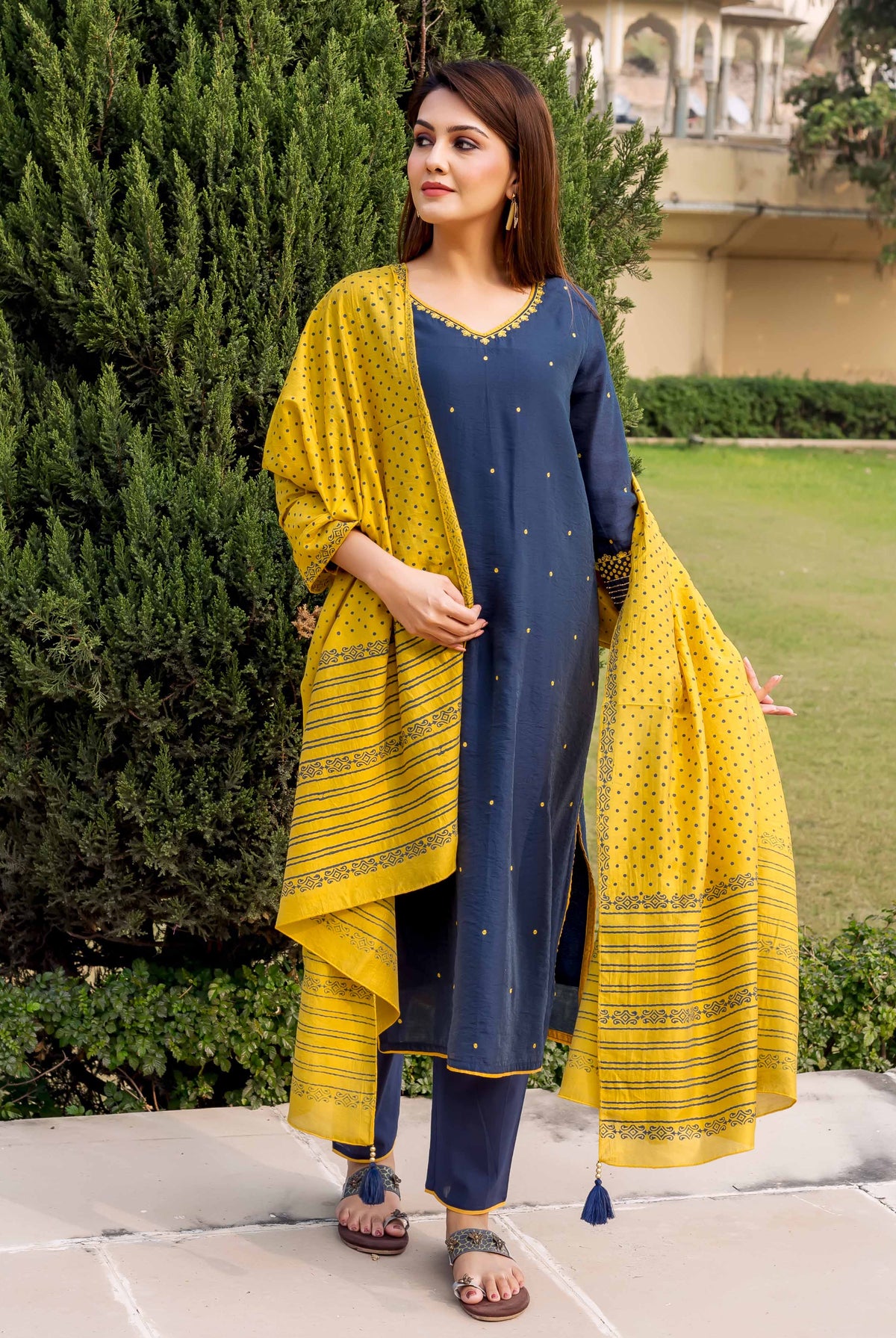 Model wears a navy blue kurta set with yellow embroidery and a yellow striped block-print dupatta.