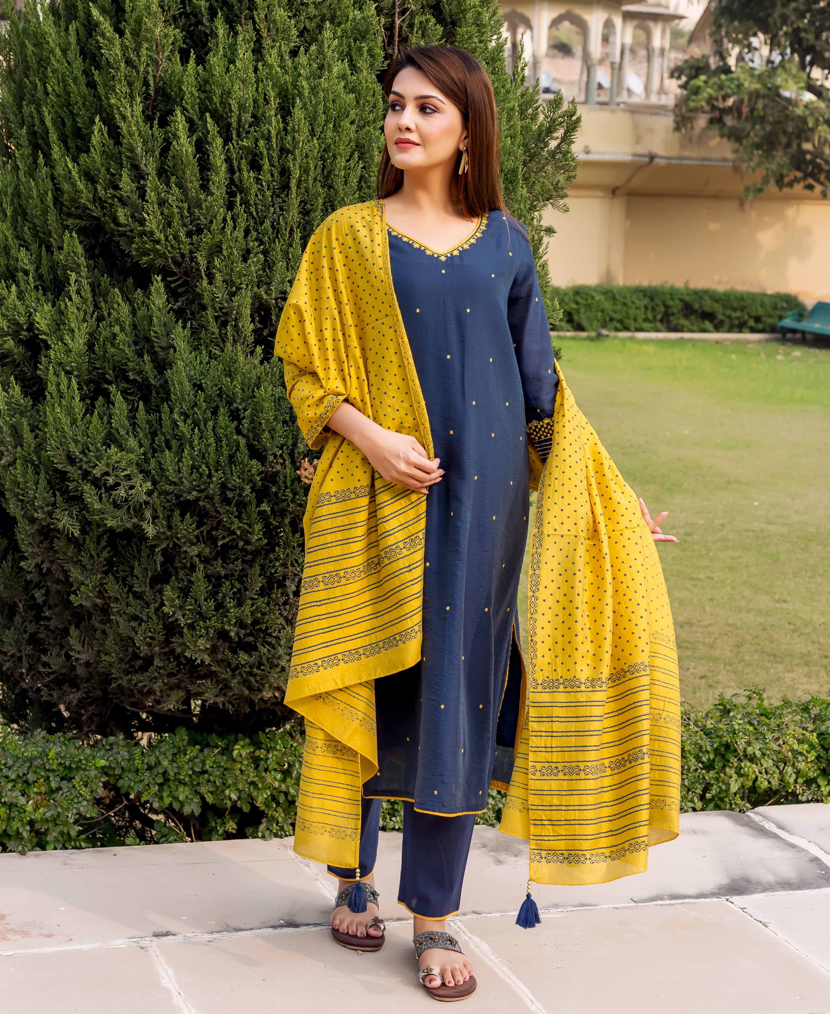 Model wears a navy blue kurta set with yellow embroidery and a yellow striped block-print dupatta.