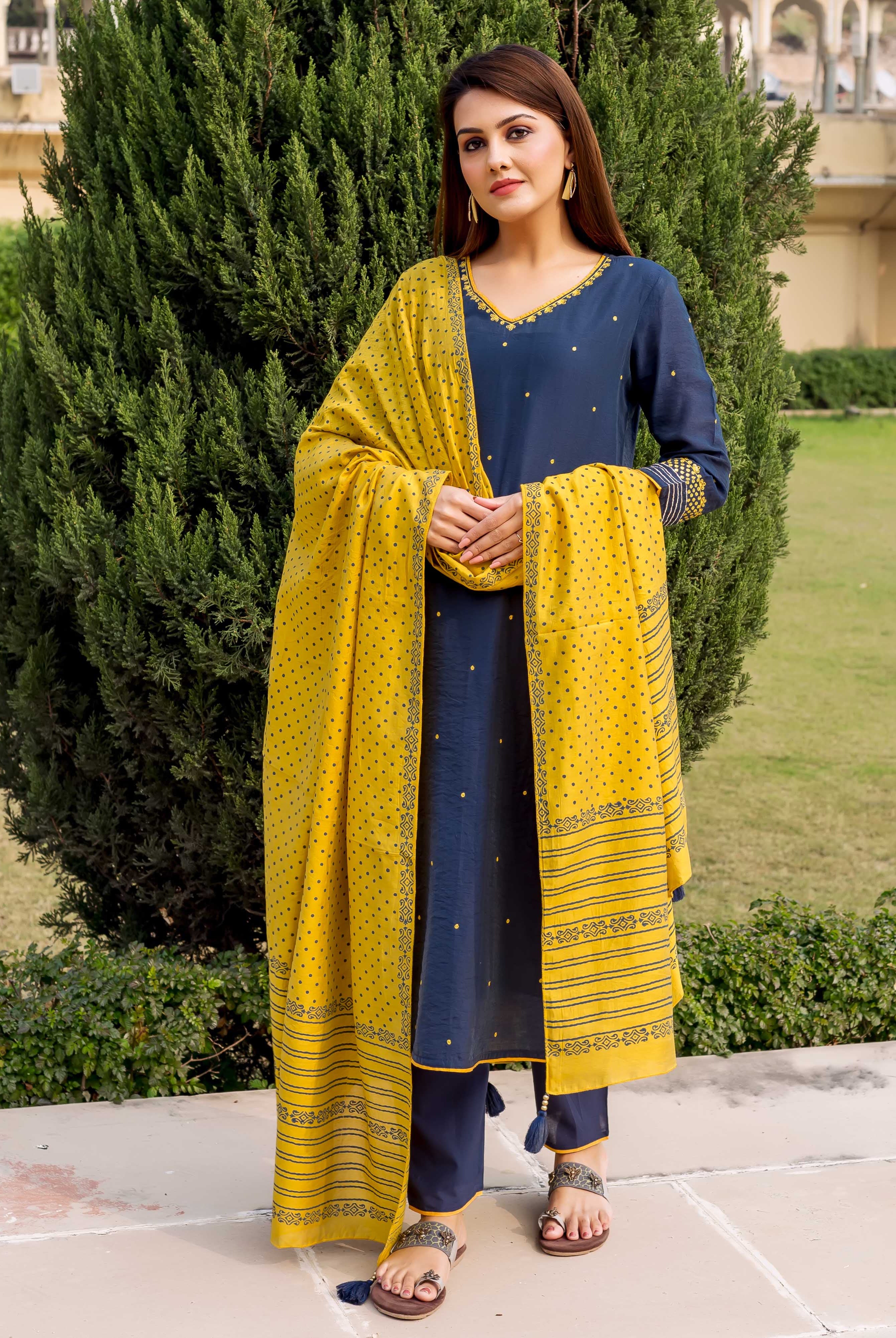 Front full look of model in navy blue embroidered kurta with yellow hand-block-printed dupatta.