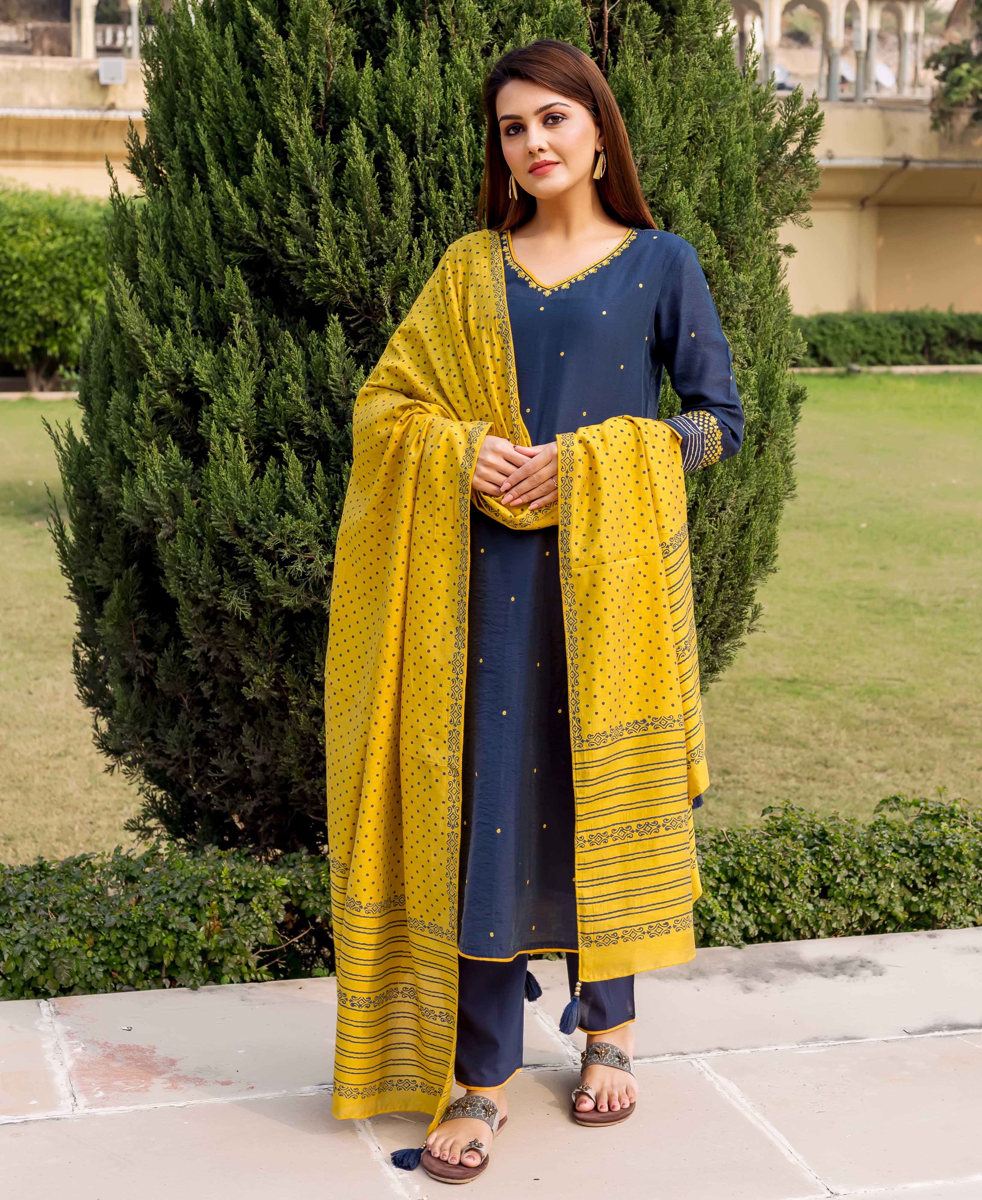 Front full look of model in navy blue embroidered kurta with yellow hand-block-printed dupatta.