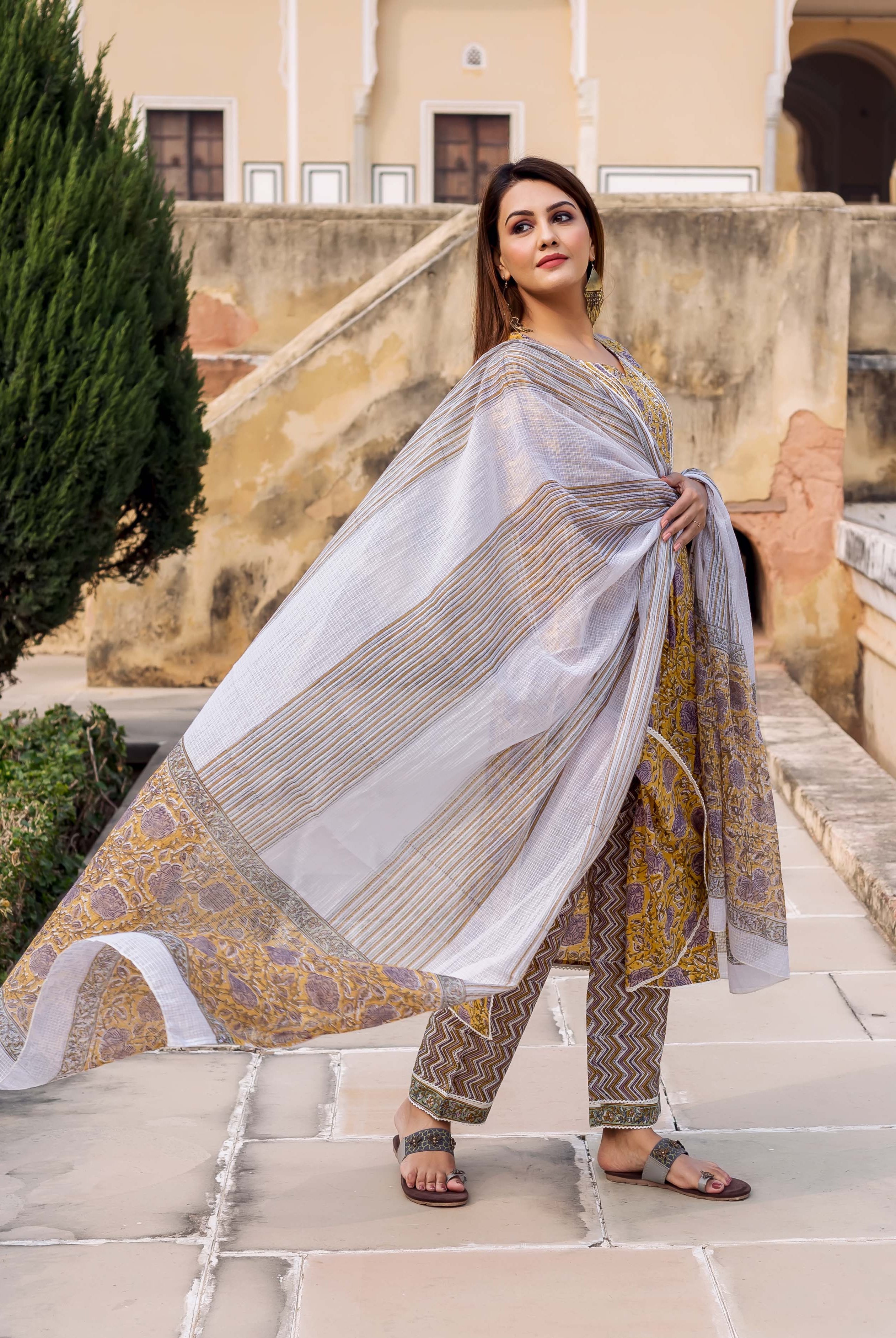 Yellow and grey hand block printed straight kurta set on model with flowing dupatta.