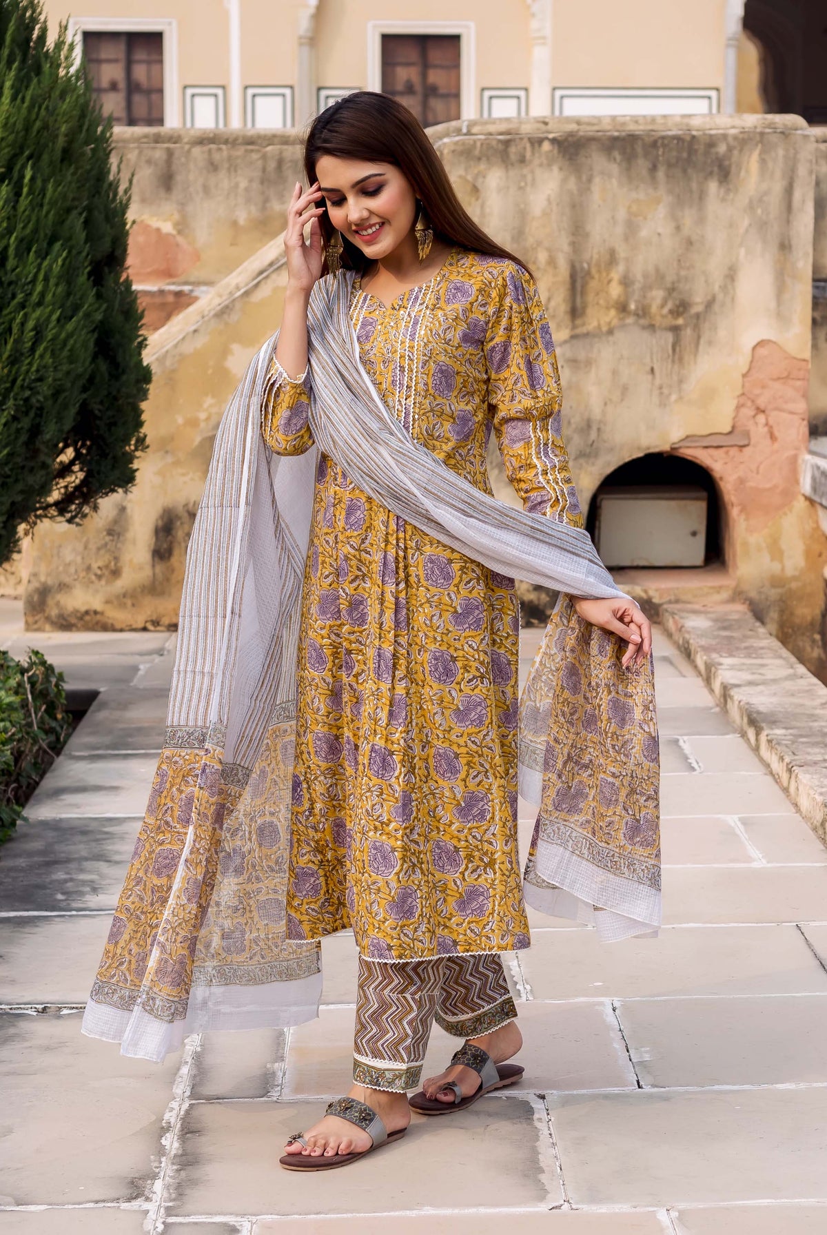 A model wearing a yellow and grey hand-block-printed kurta with a matching dupatta.