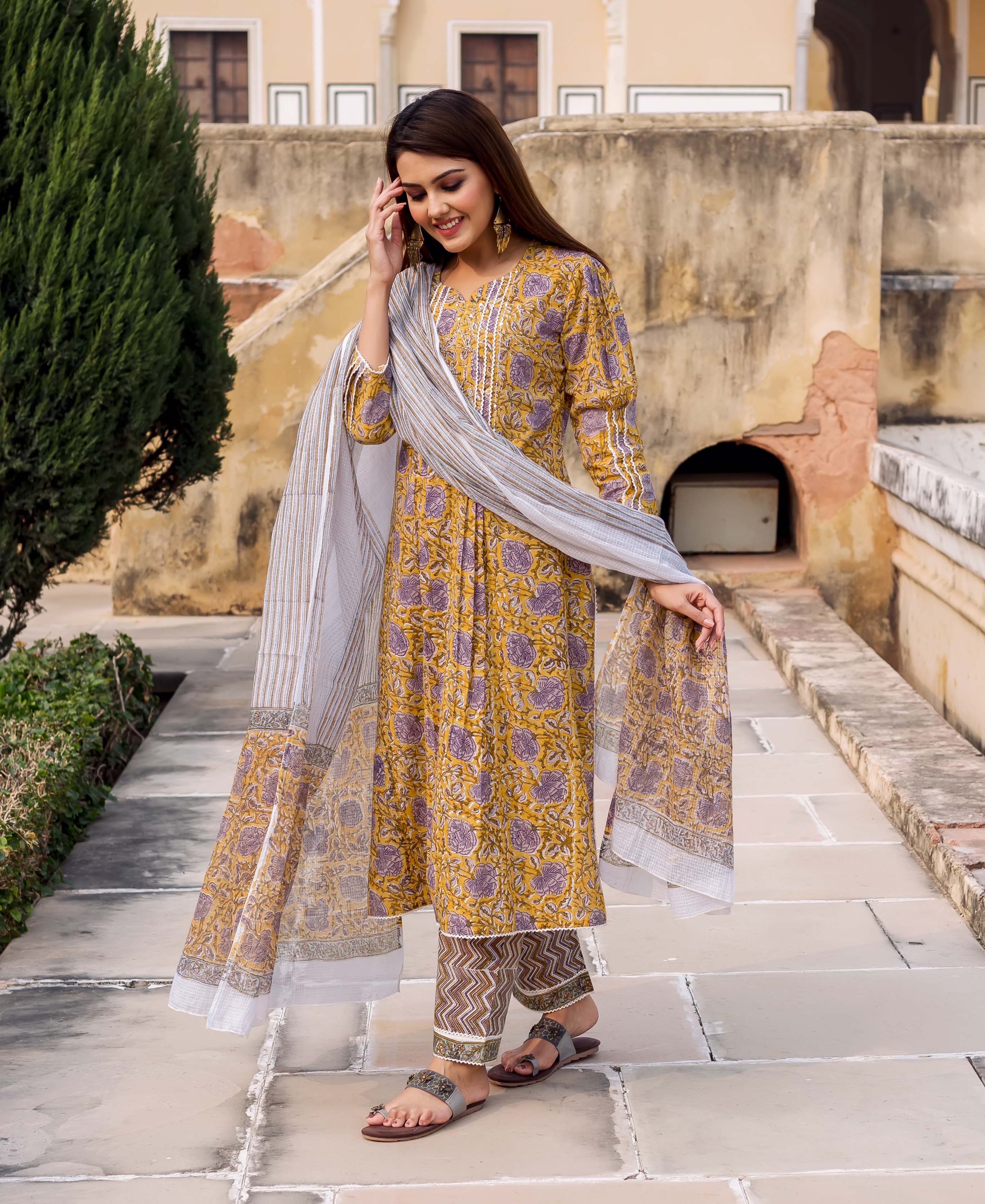 A model wearing a yellow and grey hand-block-printed kurta with a matching dupatta.