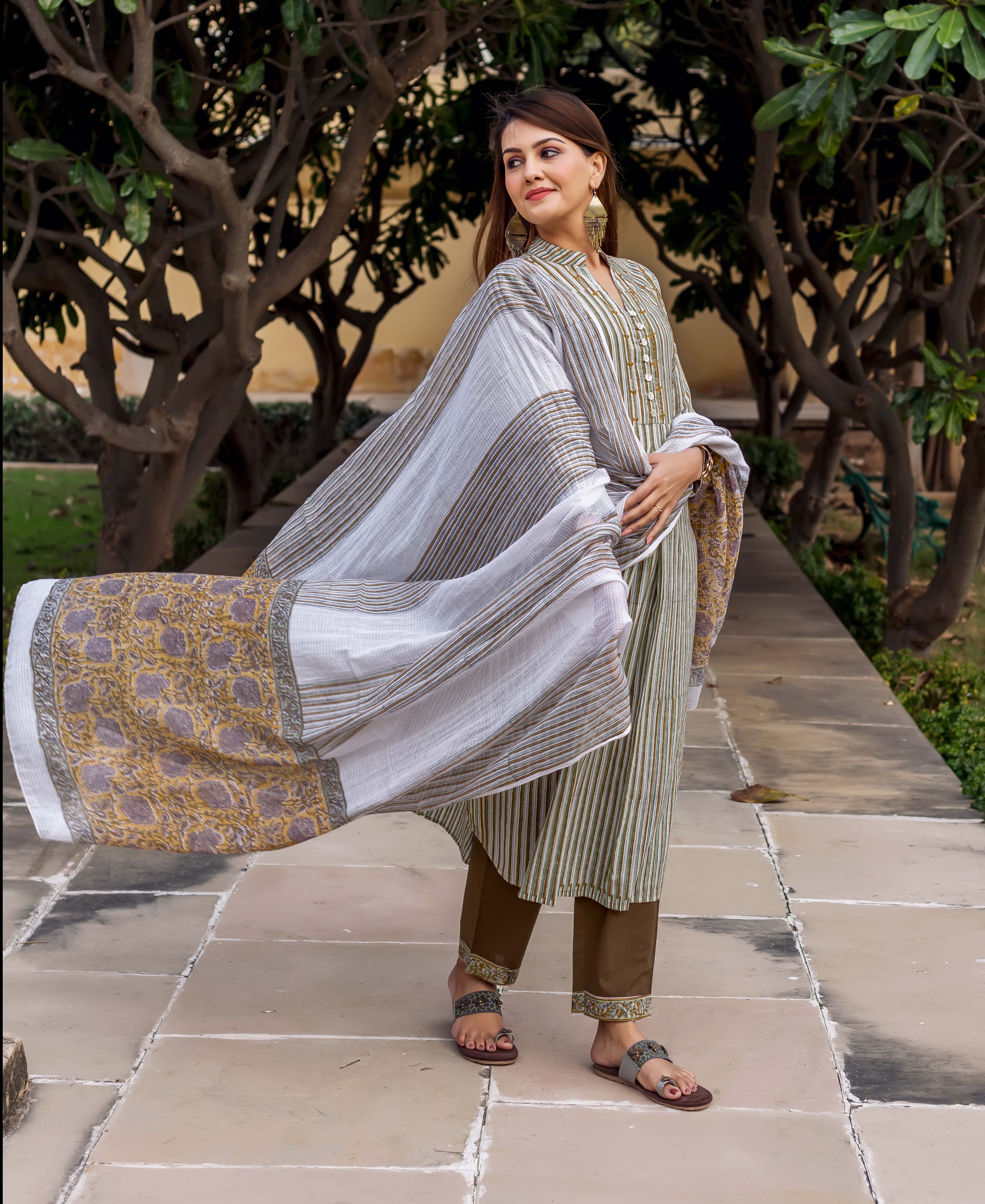 Full-body model wears olive green striped embroidered kurta set with block-printed dupatta and pants.