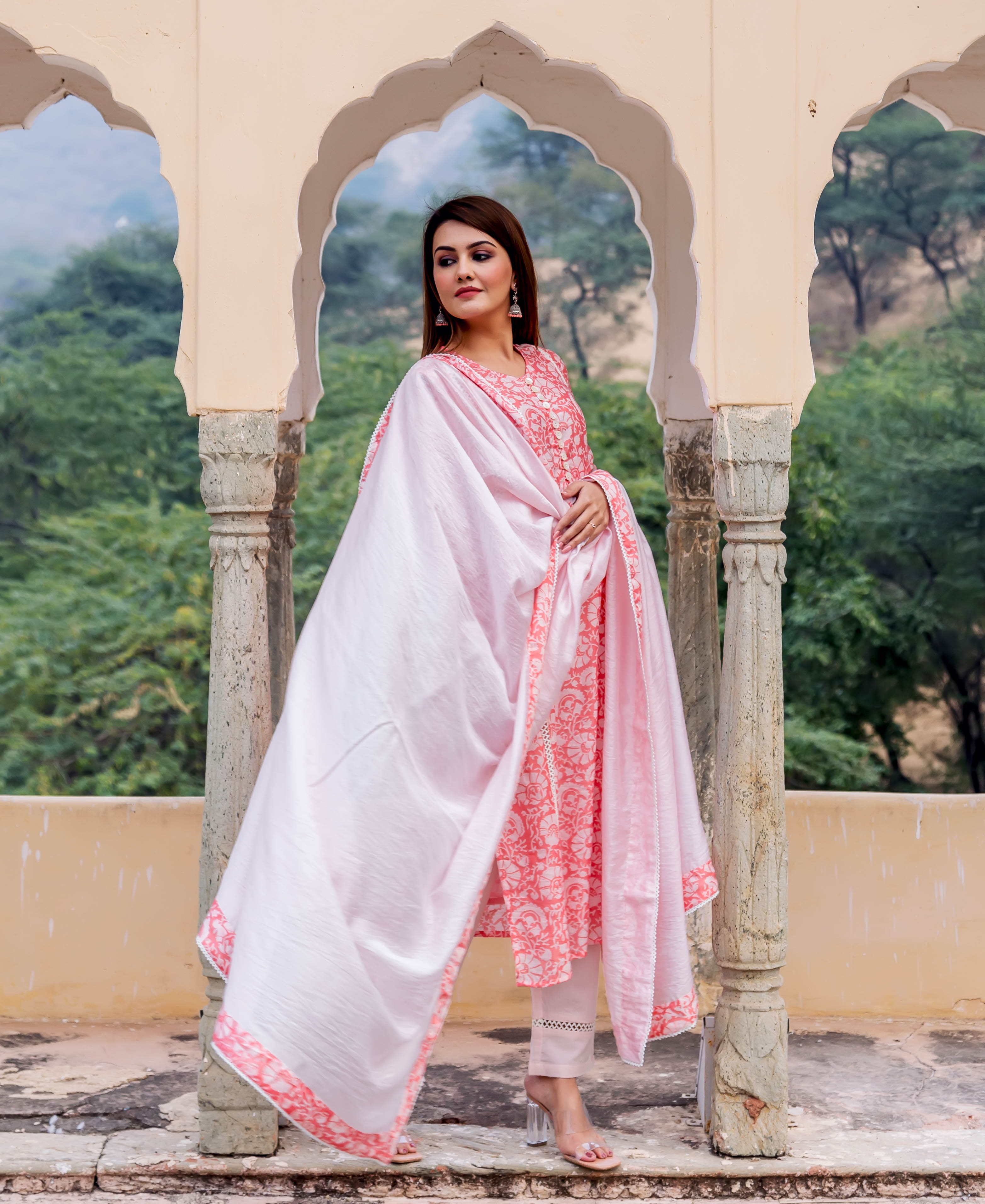 Full-body model wears a peach and white hand block printed kurta, white pants, and pink dupatta.