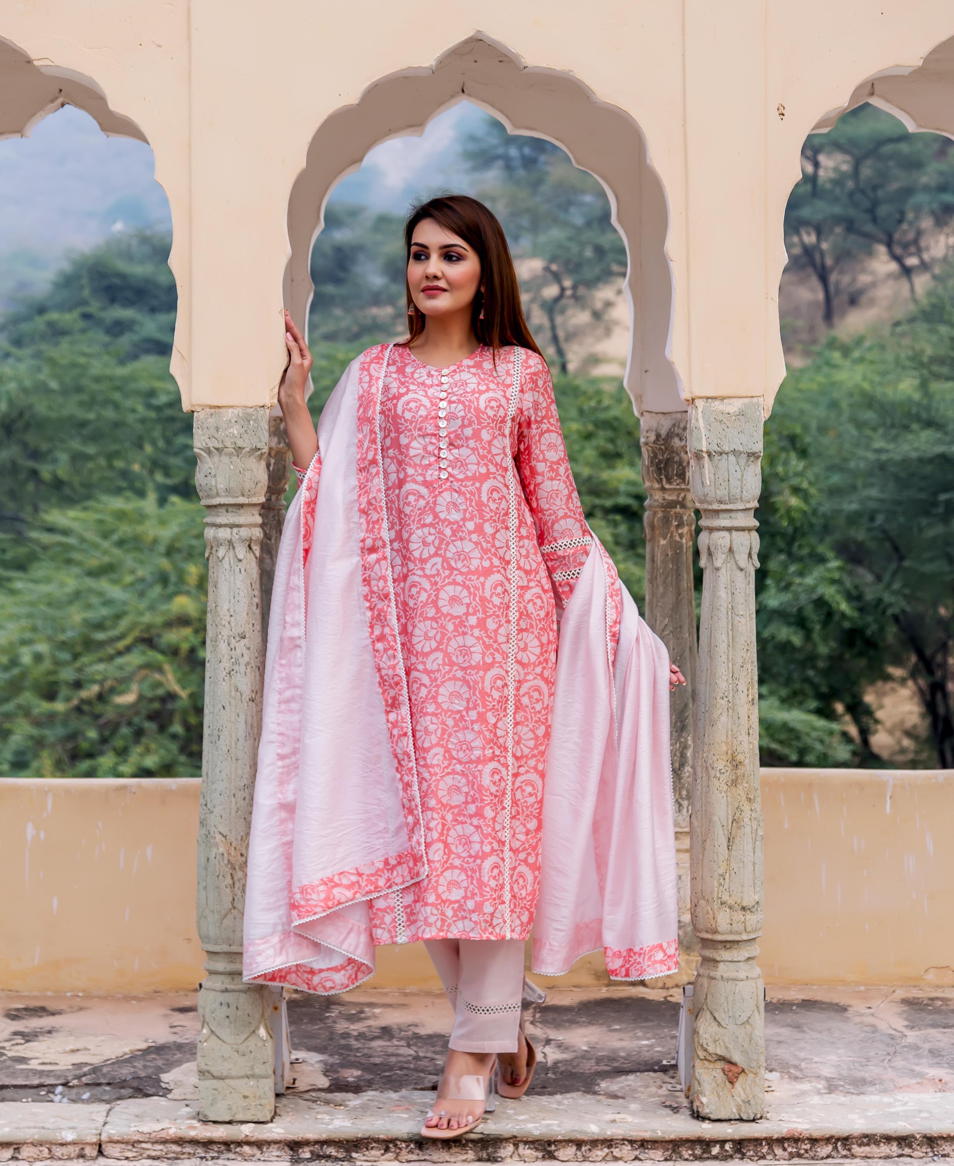 Model standing in a peach and white hand-block printed floral kurta with delicate lace trim.