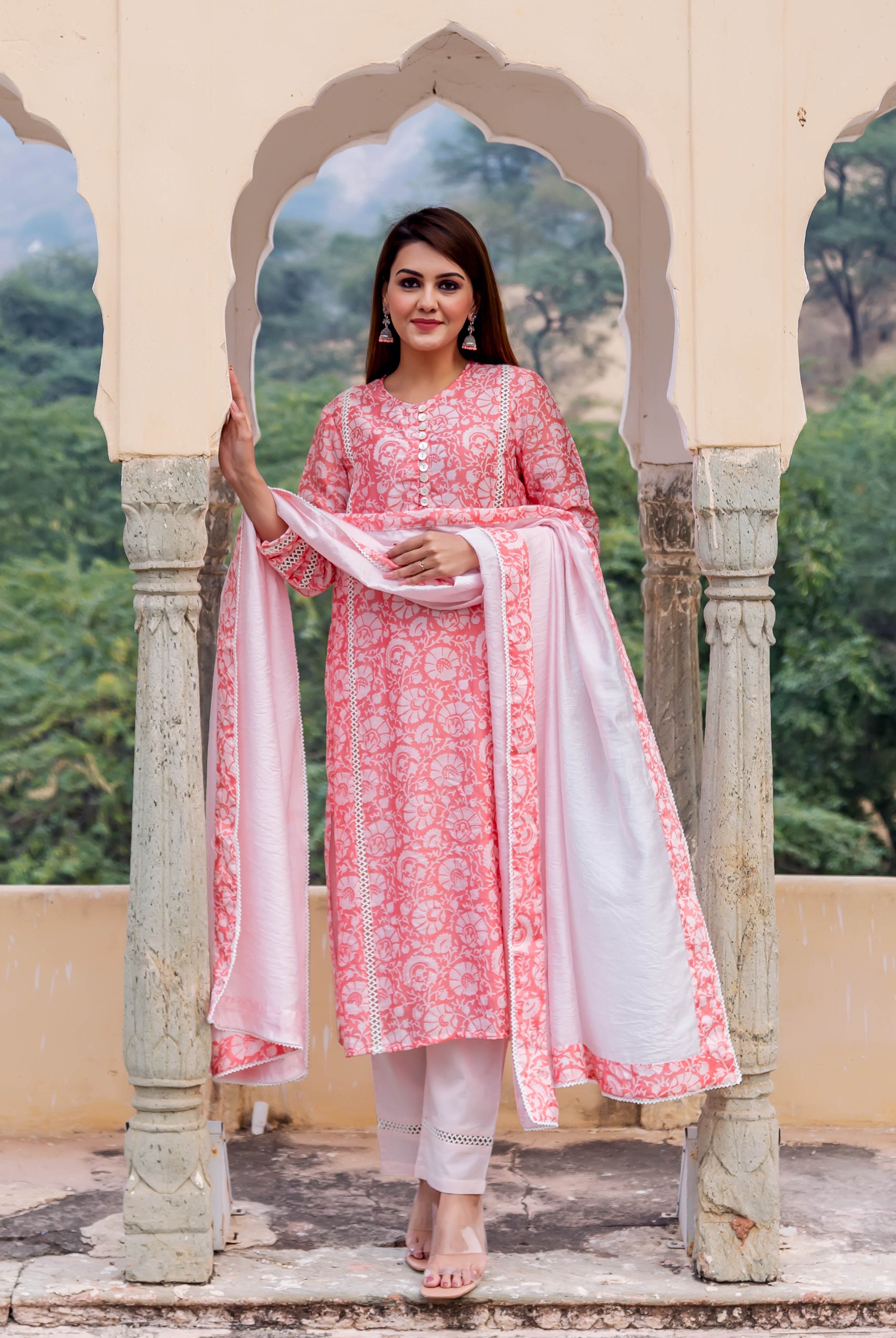 Full-length model in peach hand-block printed kurta set with white floral patterns and lace trim.