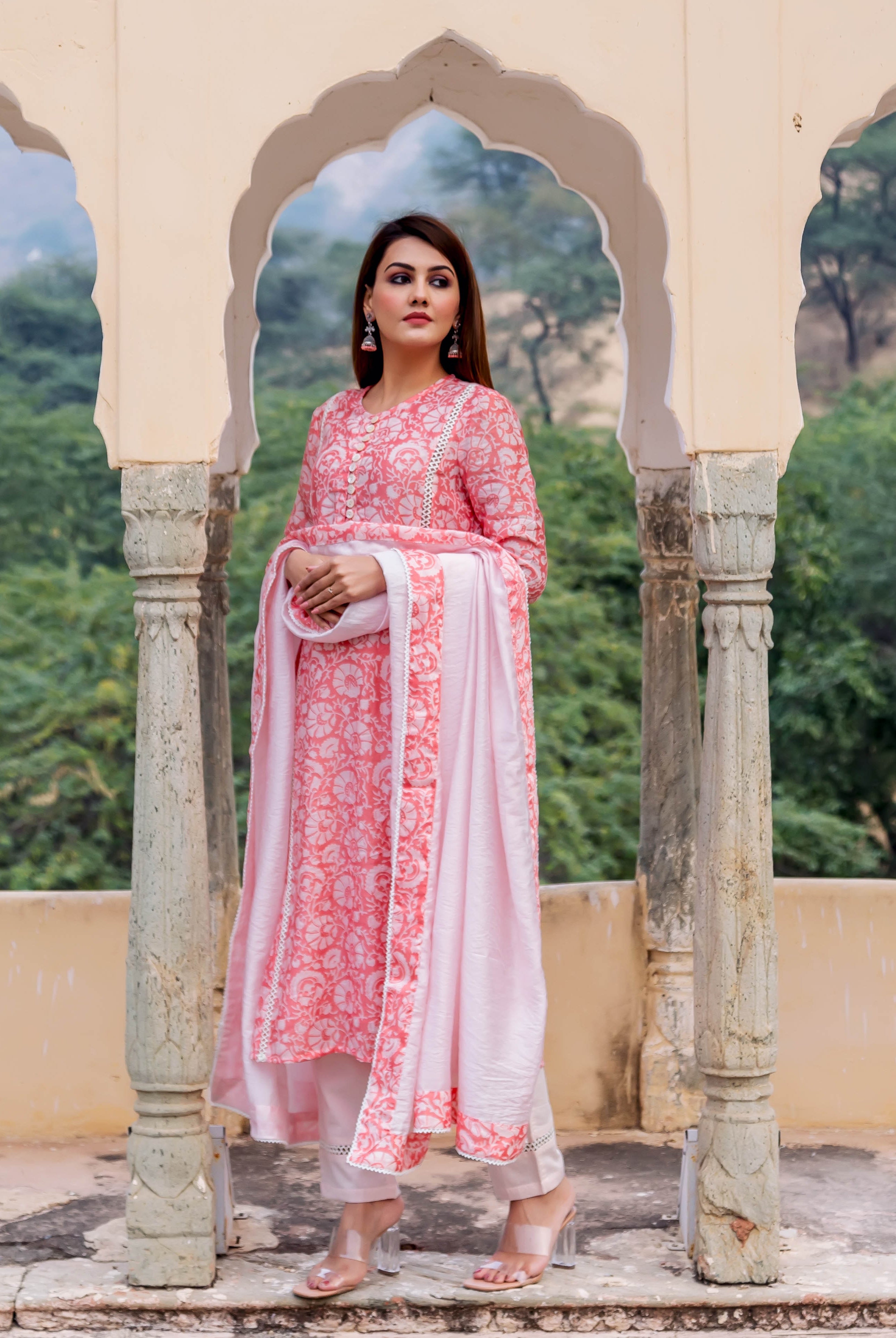 Full-length model wears a peach hand block printed floral kurta with light pink dupatta and pants.