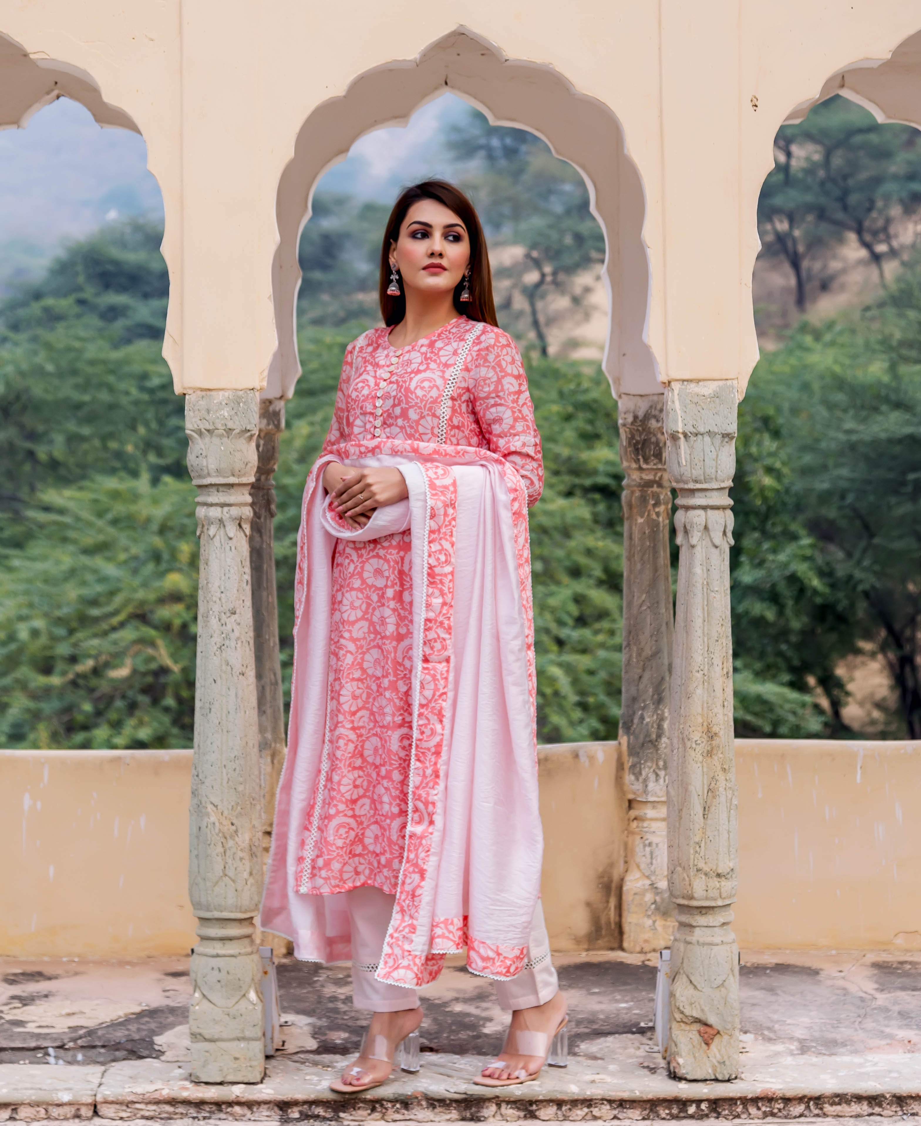 Full-length model wears a peach hand block printed floral kurta with light pink dupatta and pants.