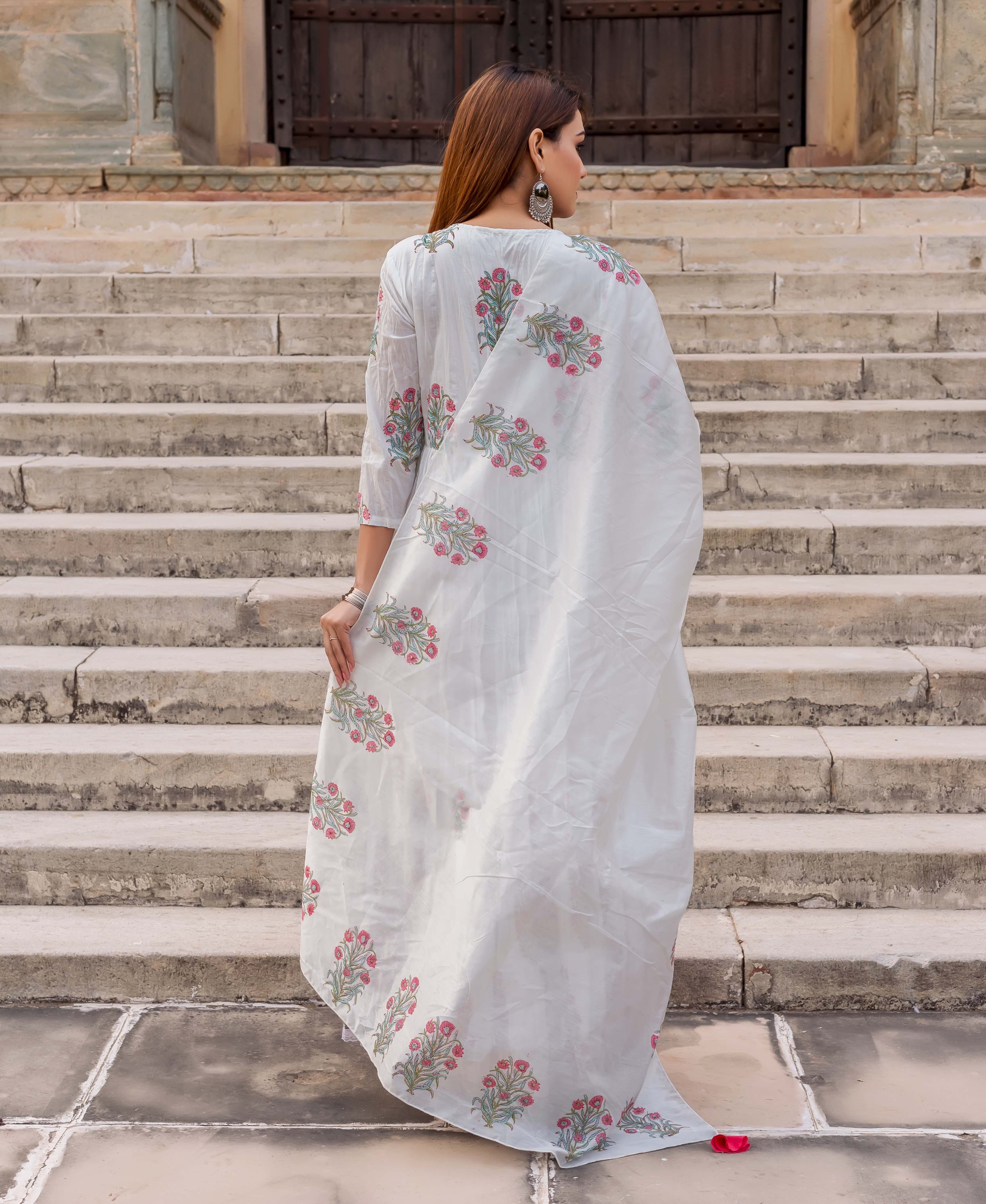 Model from back in white butta printed tiered dress with pink flowers.