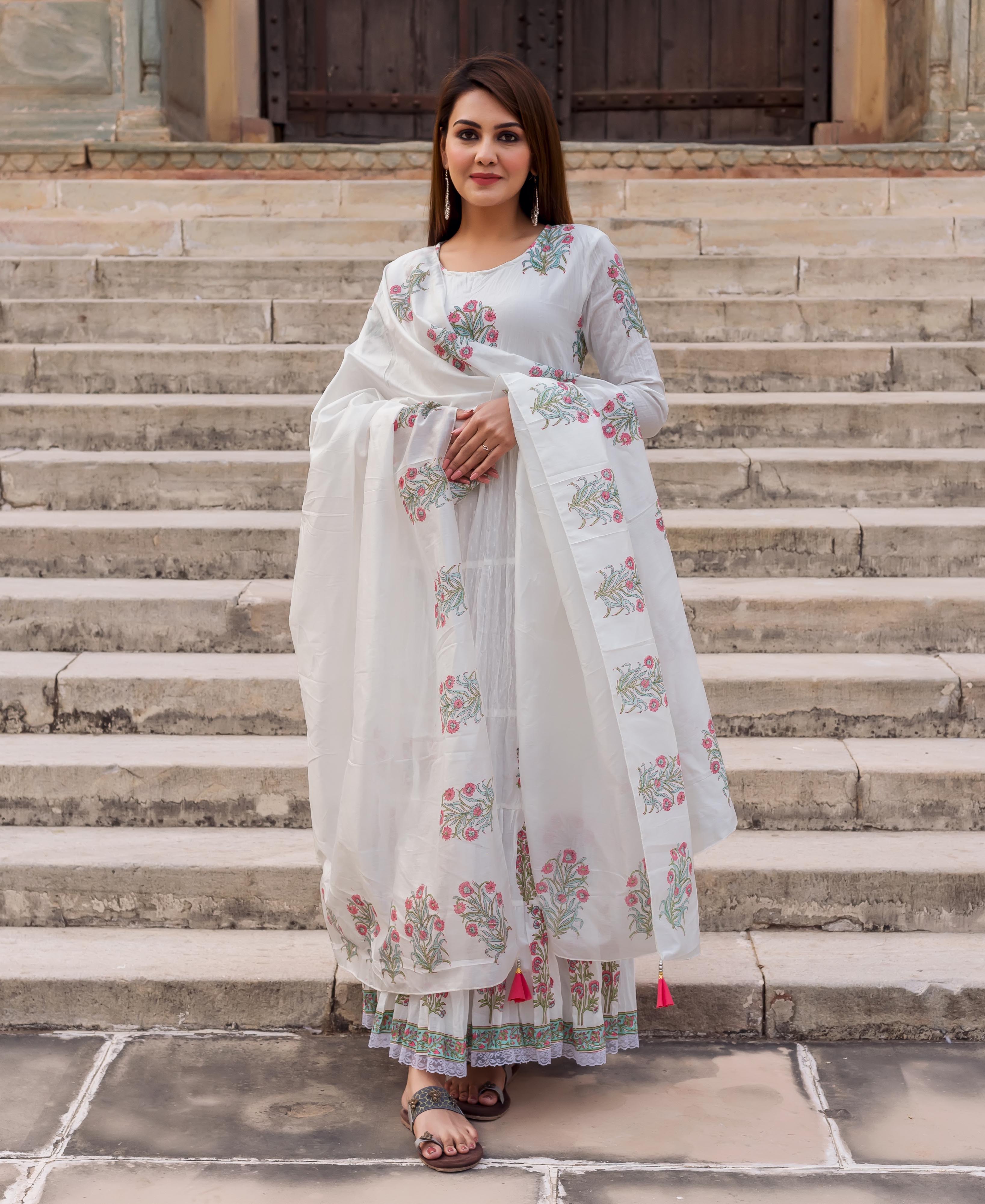 Full-length model wears a white butta printed tiered dress with a matching dupatta.