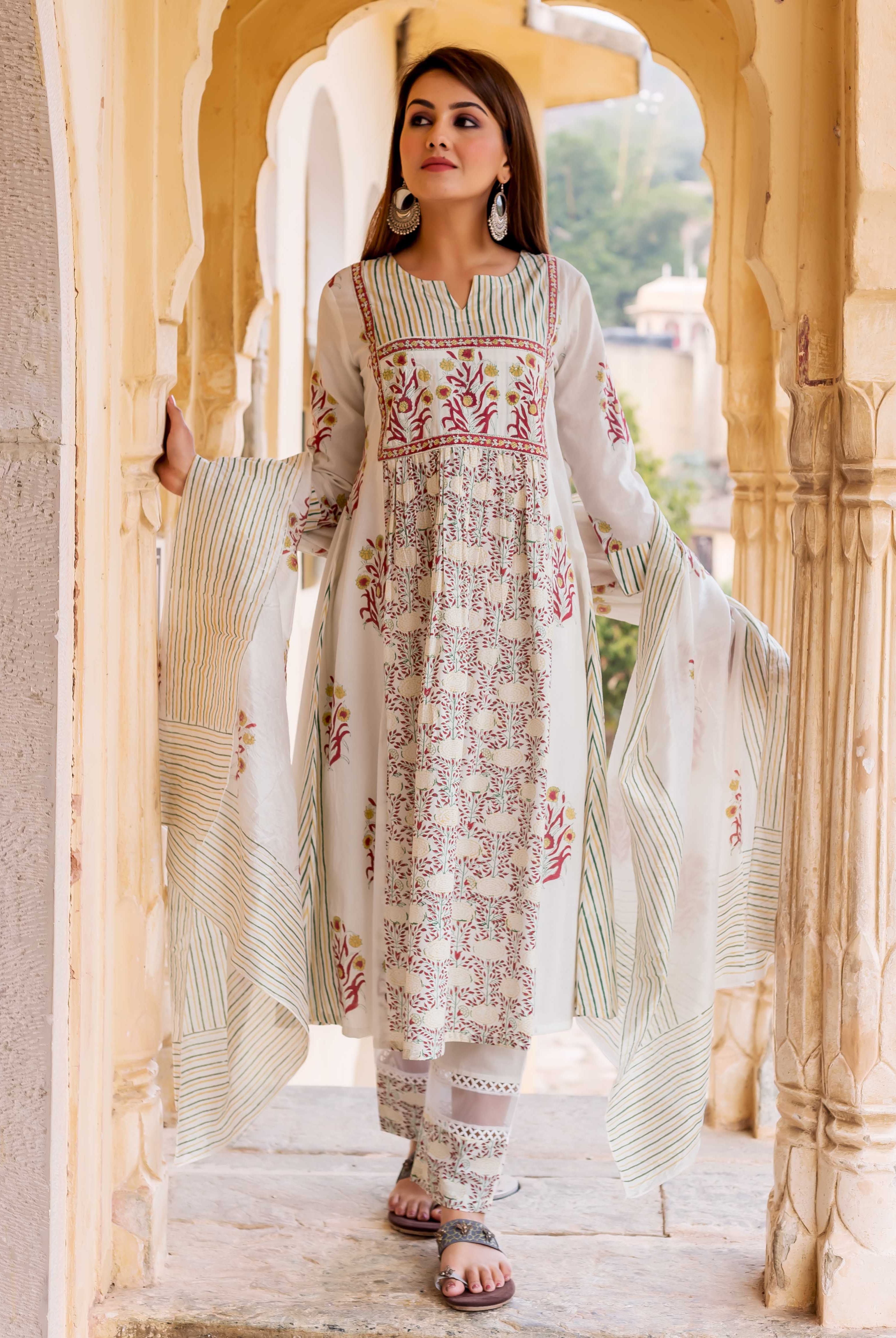Model wearing a white hand-block printed kurta set with vibrant floral and striped patterns.